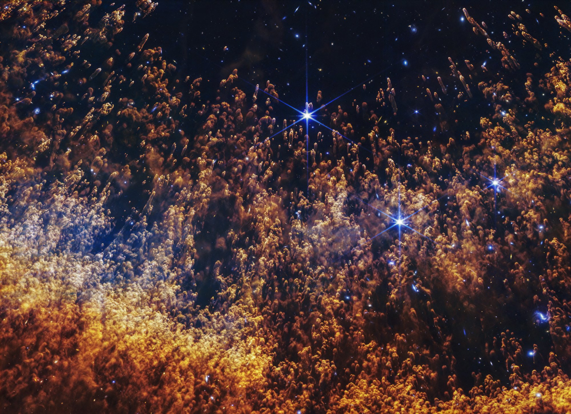 A vivid image of a star in space with surrounding colorful cosmic dust and stars.