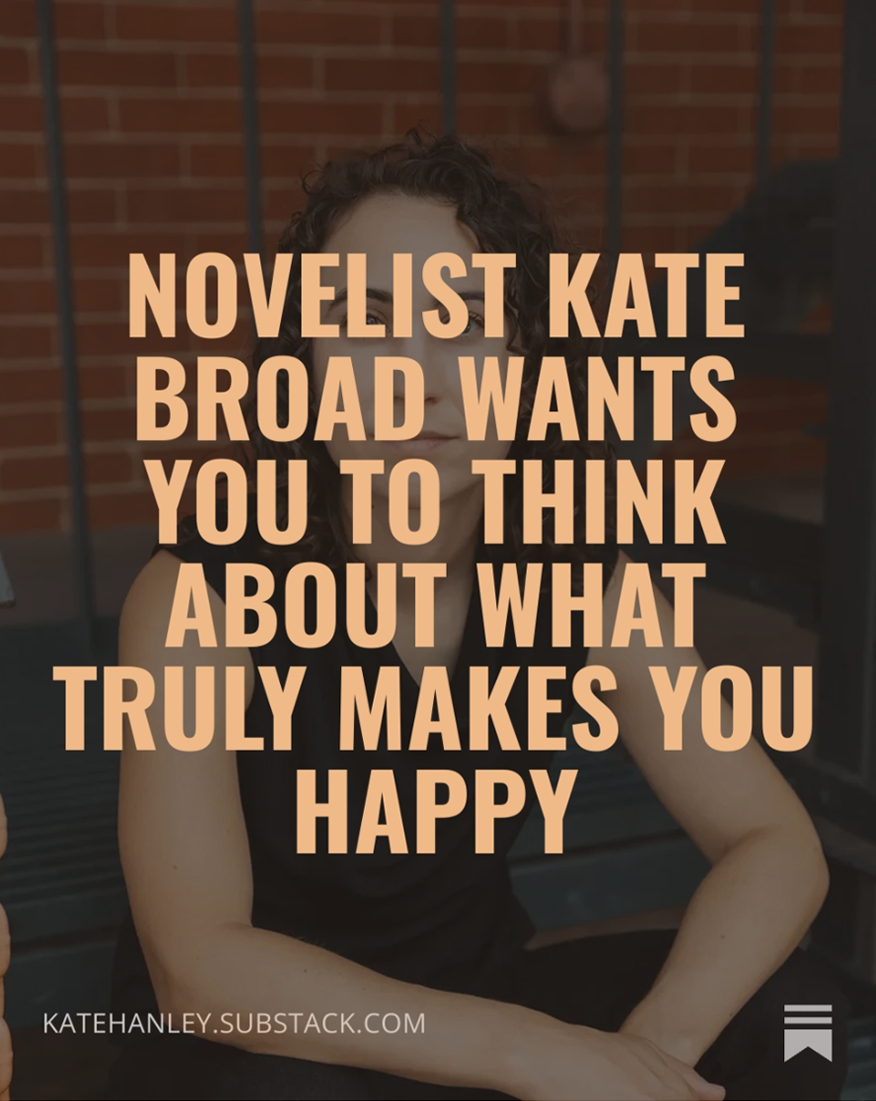 Quote over a woman with curly dark hair sitting indoors with a brick wall background, saying, 'Novelists Kate Broad wants you to think about what truly makes you happy.'
