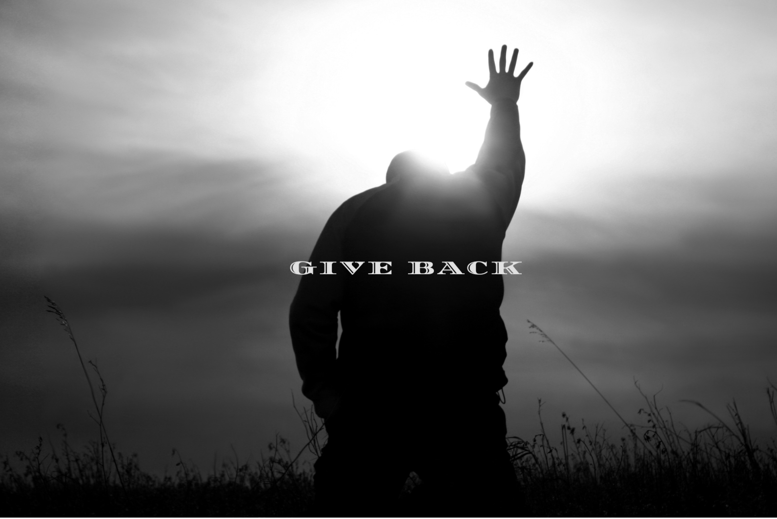 Silhouette of a person with one arm raised, standing outdoors during sunset or sunrise, with the words 'Give Back' overlaid.