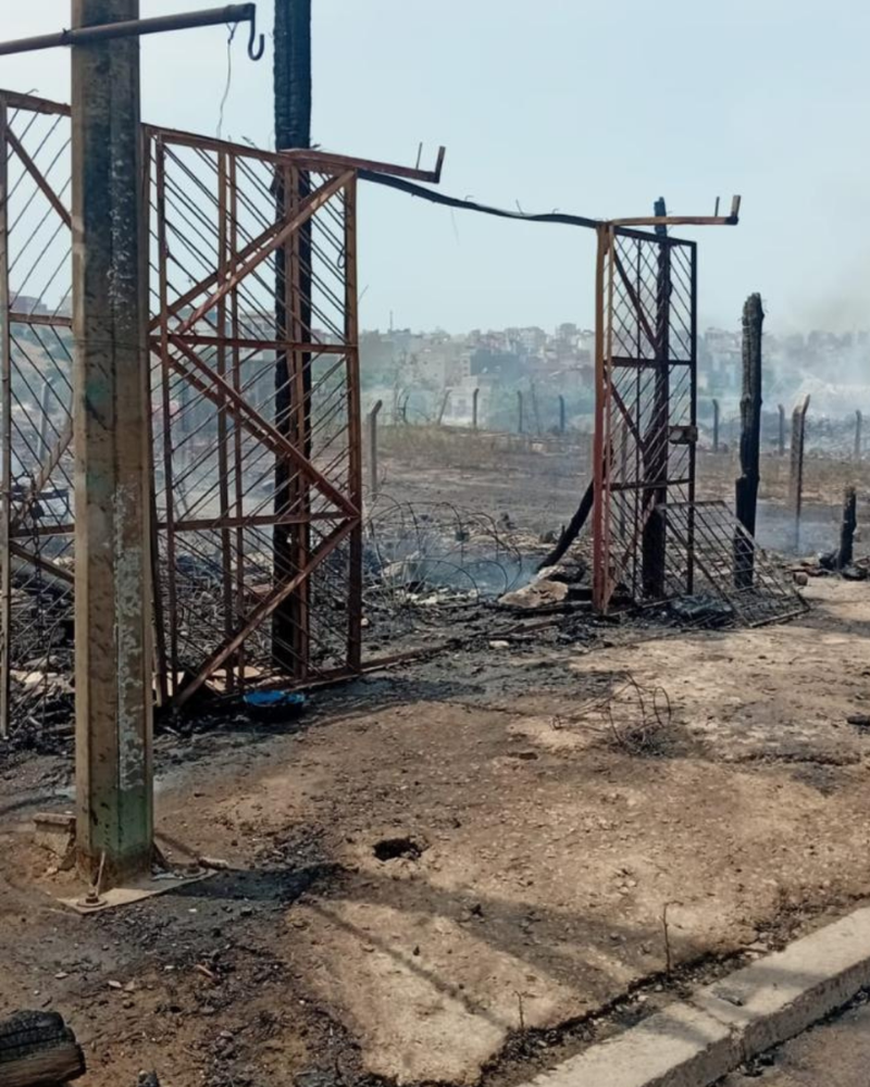 The shell of a fire-damaged shop, with just the metal skeleton remaining.