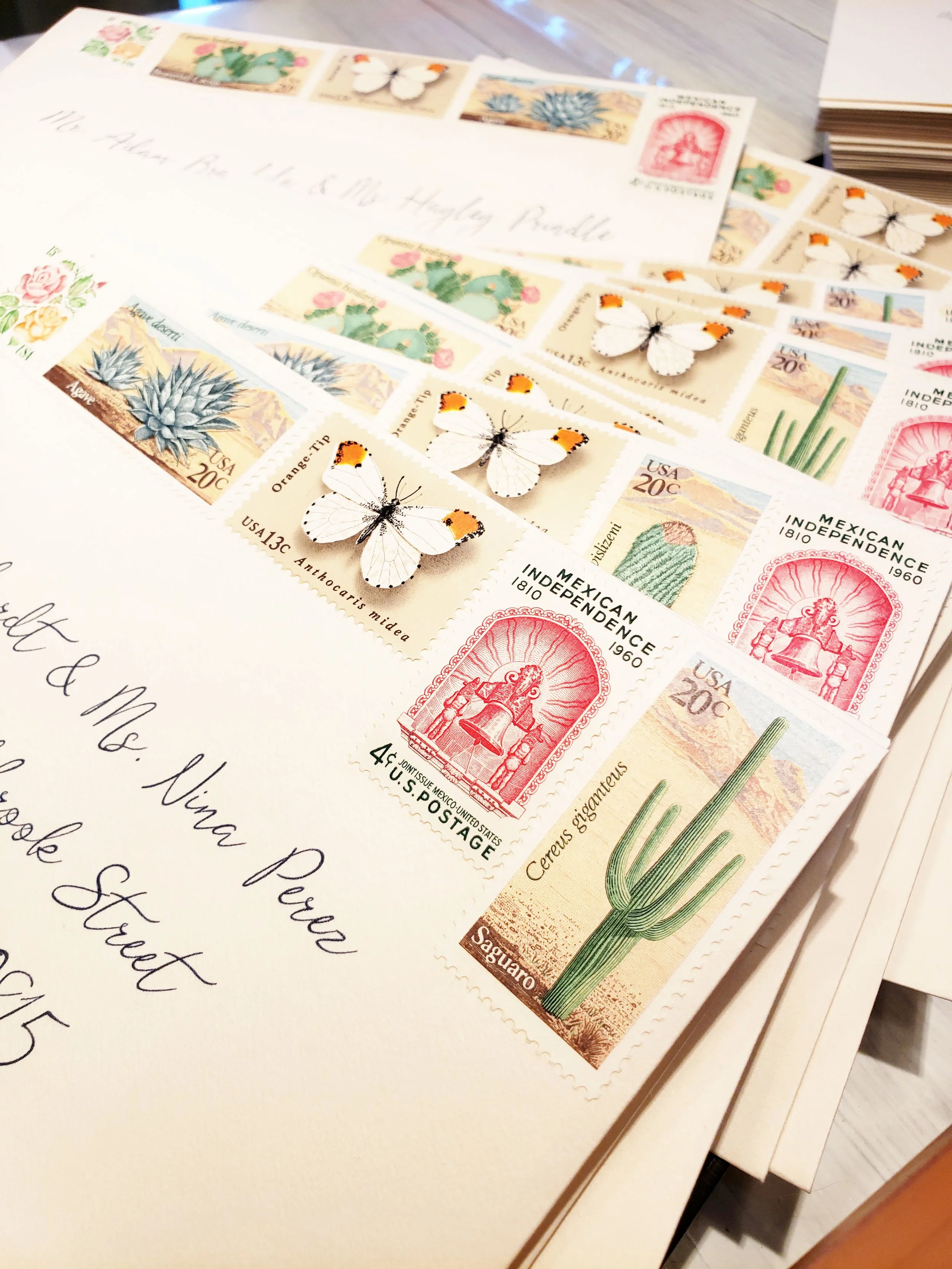 A letter with several postage stamps featuring cacti, butterflies, and Mexican Independence motifs, along with decorative butterfly embellishments.