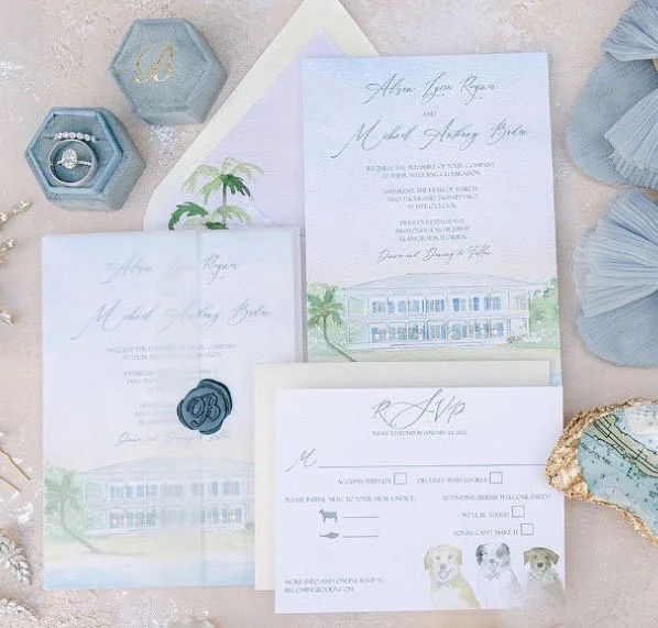 Wedding invitation suite with blue and pastel accents, including a main invitation, RSVP card, and enclosure card, adorned with palm tree illustrations, and surrounded by jewelry, a hexagon box, and decorative seashells.
