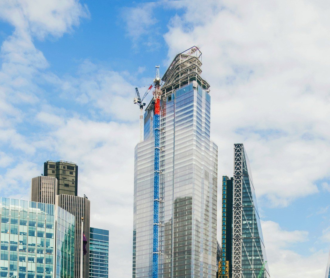 Late-stage City of London commercial tower construction beneath blue sky