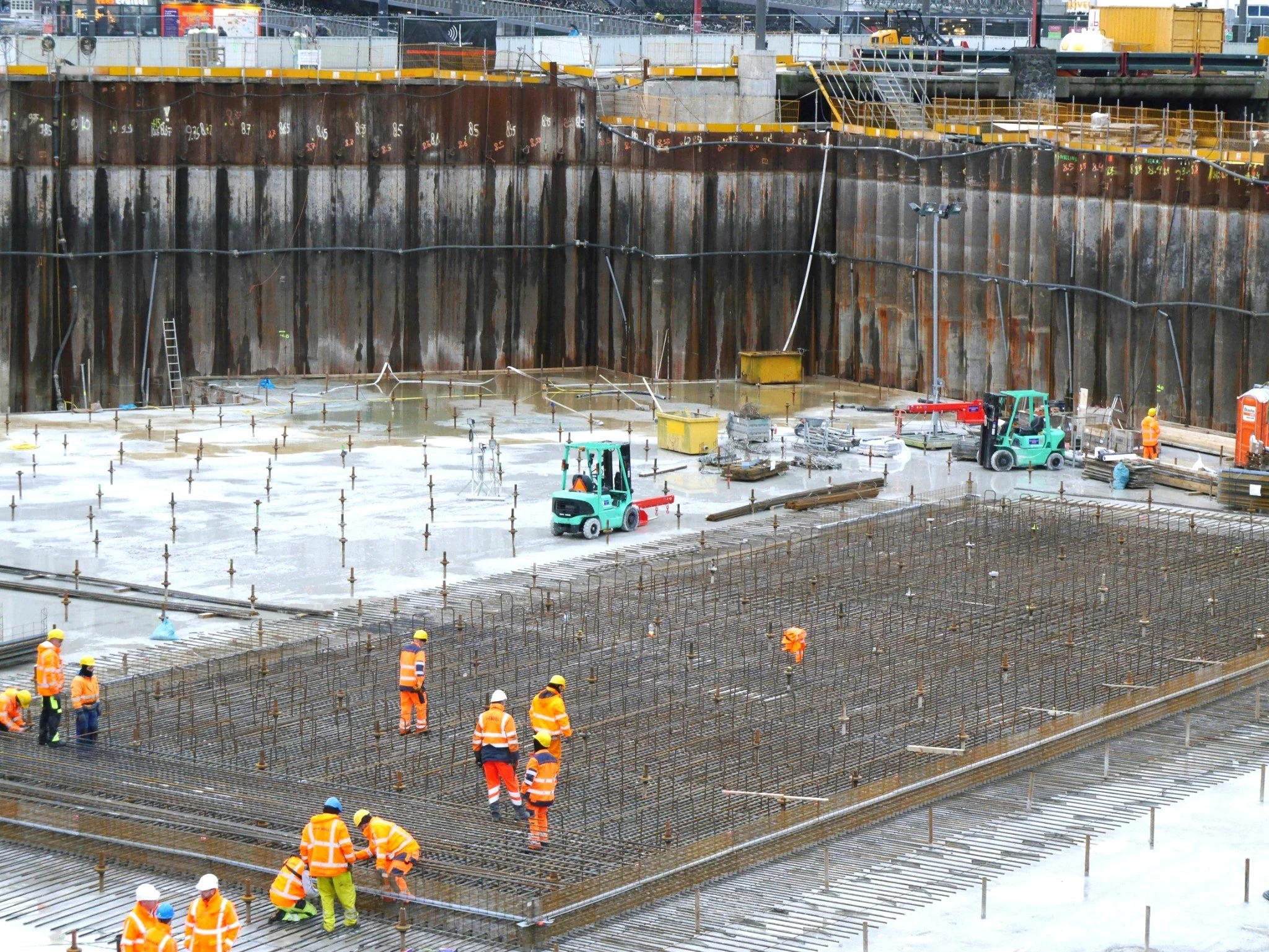 Wide active construction workface with multiple operatives carrying out live works