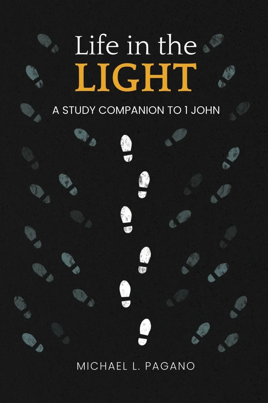 Book cover titled 'Life in the Light: A Study Companion to 1 John' by Michael L. Pagano, featuring a black background with white footprints forming a path.