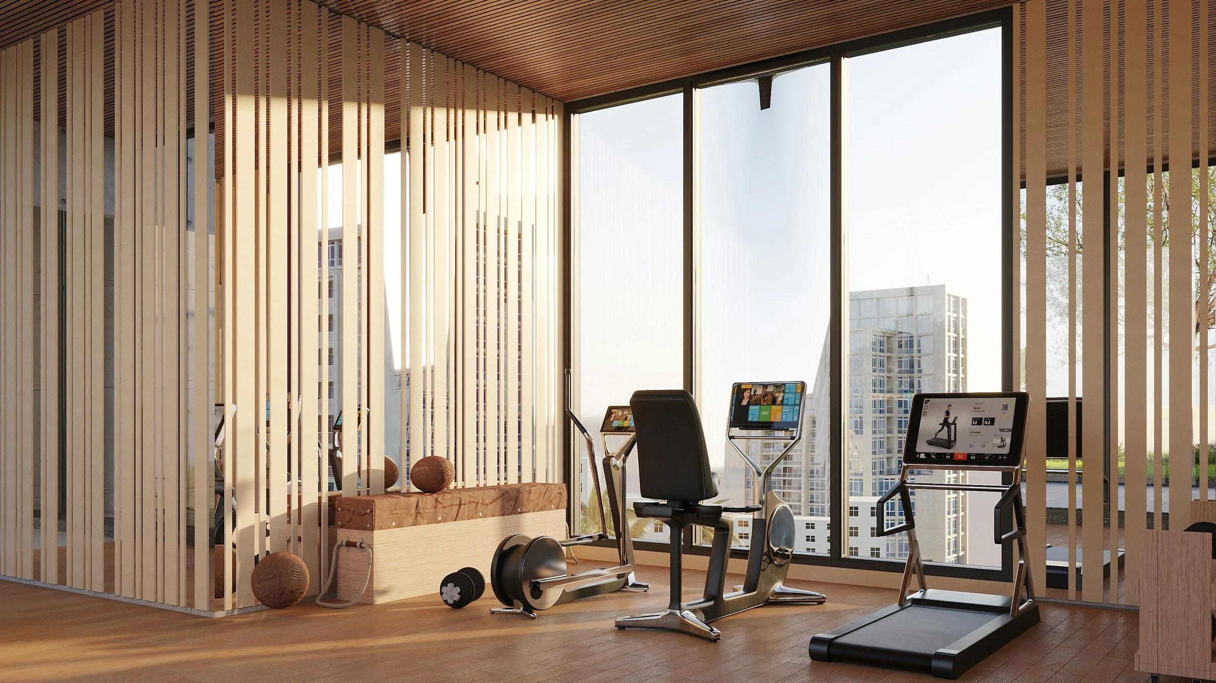 Indoor gym area with exercise equipment, including a treadmill, exercise bikes, and weights, in front of large windows with cityscape views.