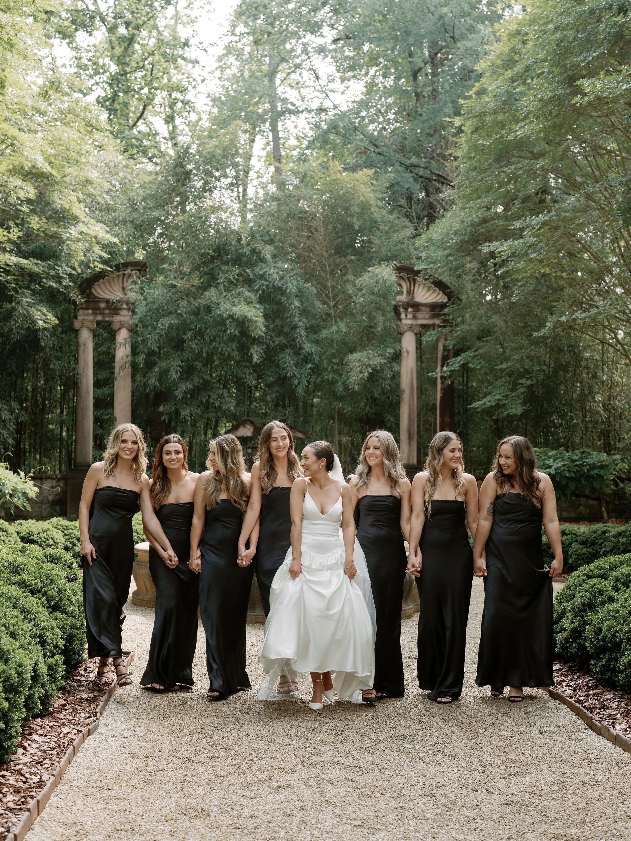 Bride and groom walking through Swan House gardens in Atlanta Georgia during romantic wedding portraits