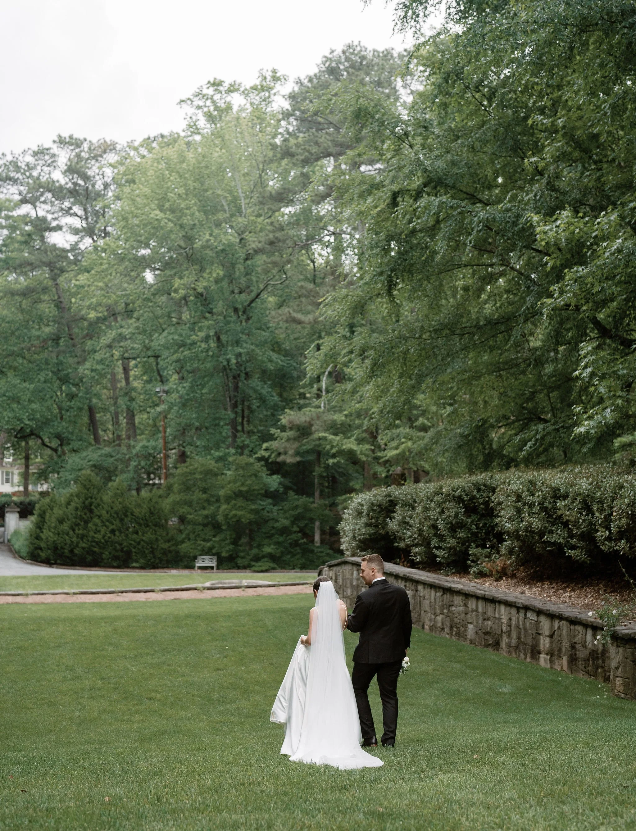 Bride and groom walking through Swan House gardens in Atlanta Georgia during romantic wedding portraits
