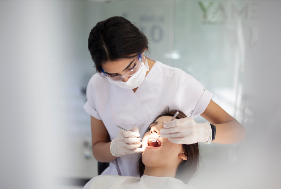 Dentist examining a patient's mouth in a dental office.