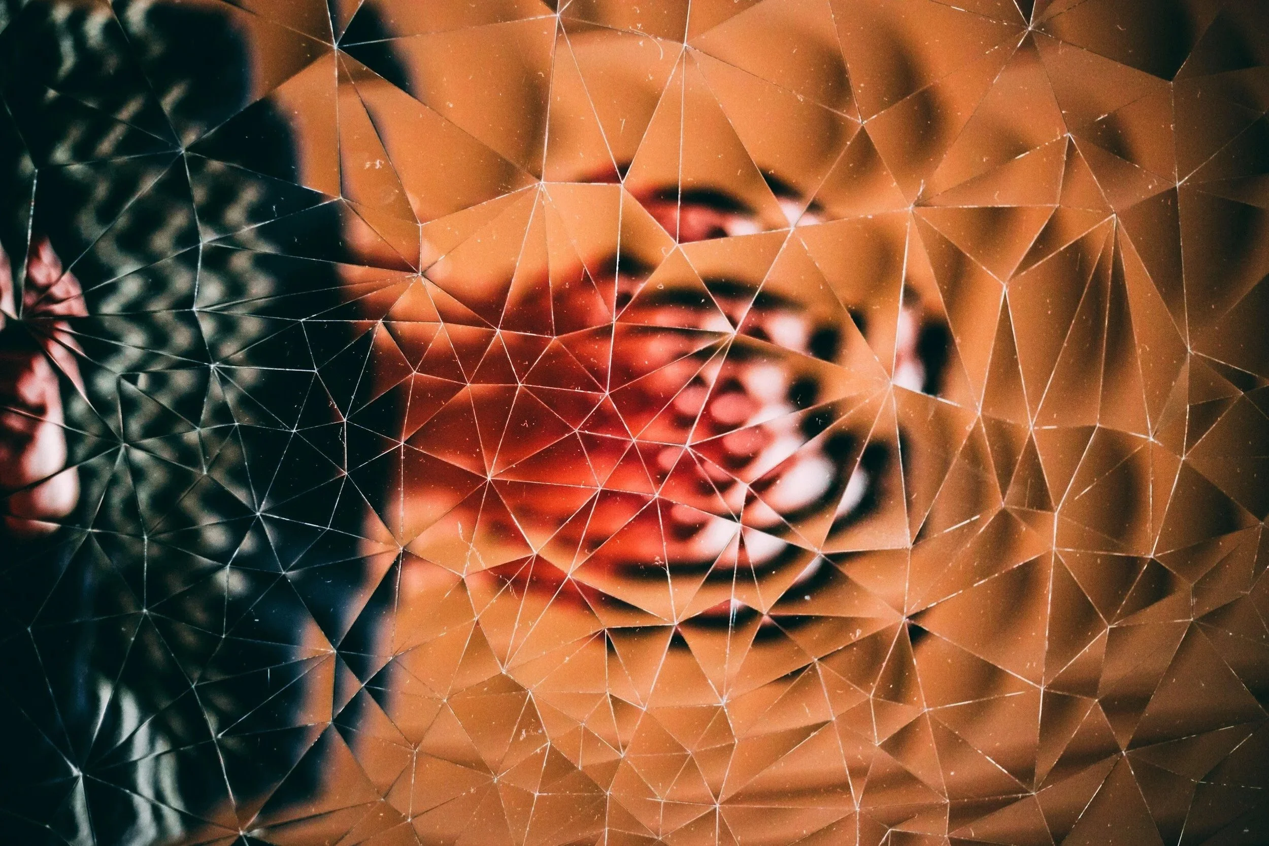An abstract digital artwork featuring a human face overlaid with geometric triangular patterns and interconnected lines, blending elements of technology and human expression.