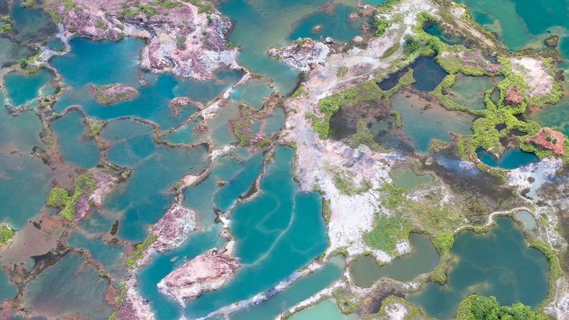 Aerial view of ponds at Frog Hill with turquoise water and abstract mineral patterns creating layered geometric forms.