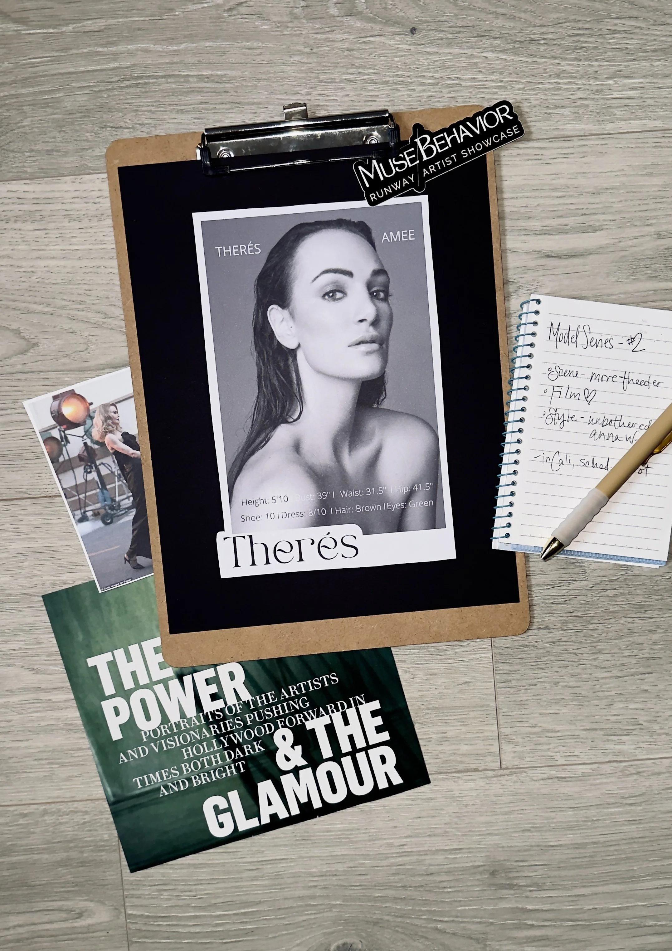 Table layout with a black and white headshot of a woman named Thérès, some photographs, a notebook with handwritten notes, and a book titled 'The Power of the Glamour'.