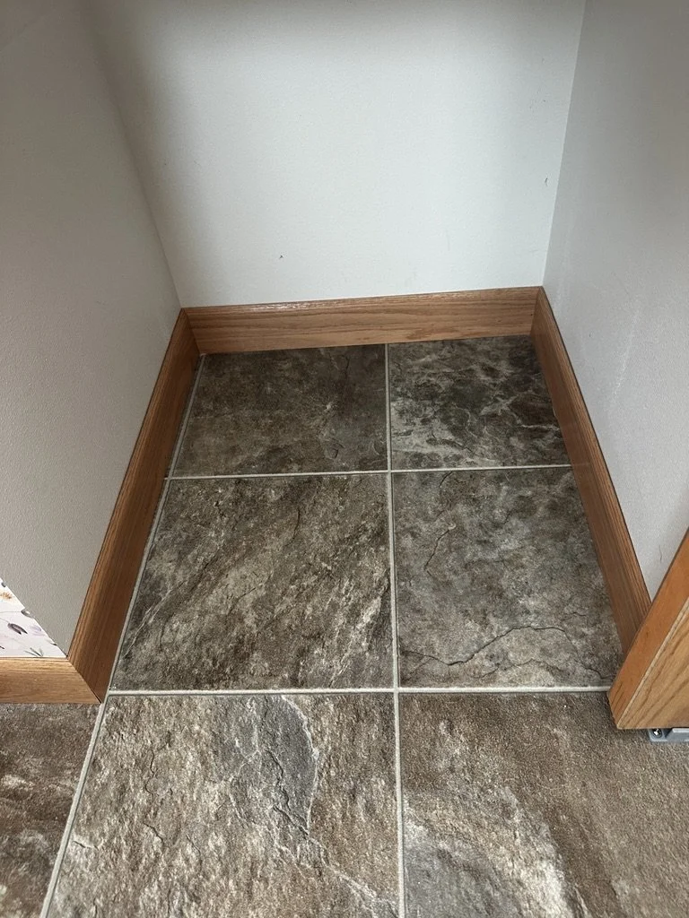 Luxury bathroom flooring featuring dark textured slate-look ceramic floor tile installation.