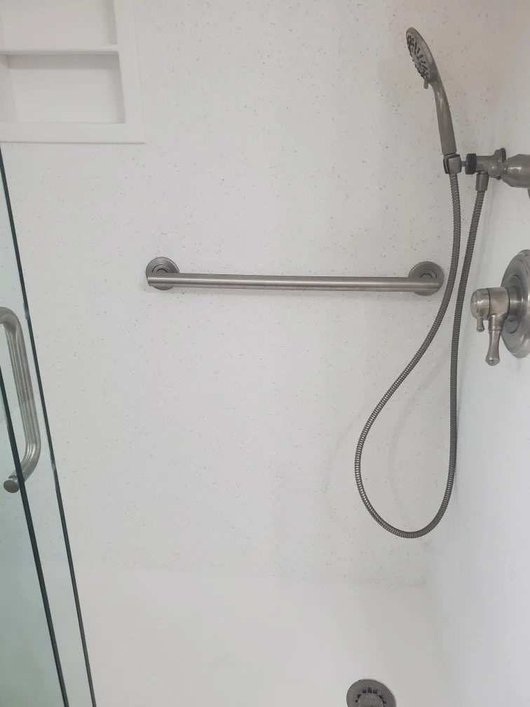 Secure wall-mounted grab bar installed directly into a durable solid surface shower wall.