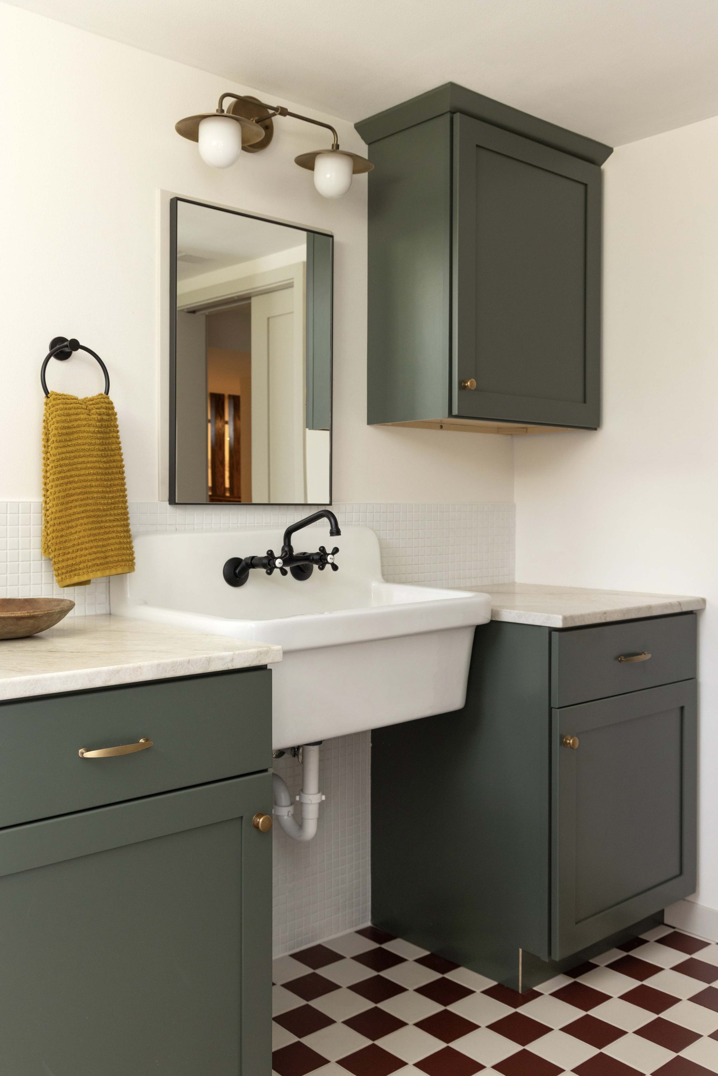 Custom bathroom vanity build by Root Down Remodeling featuring an undermount utility sink and wall-mount faucet.