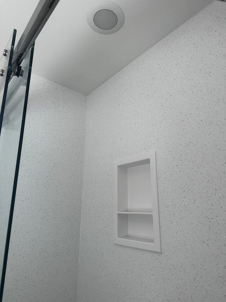 Angular view of a seamless recessed storage niche built into shower walls