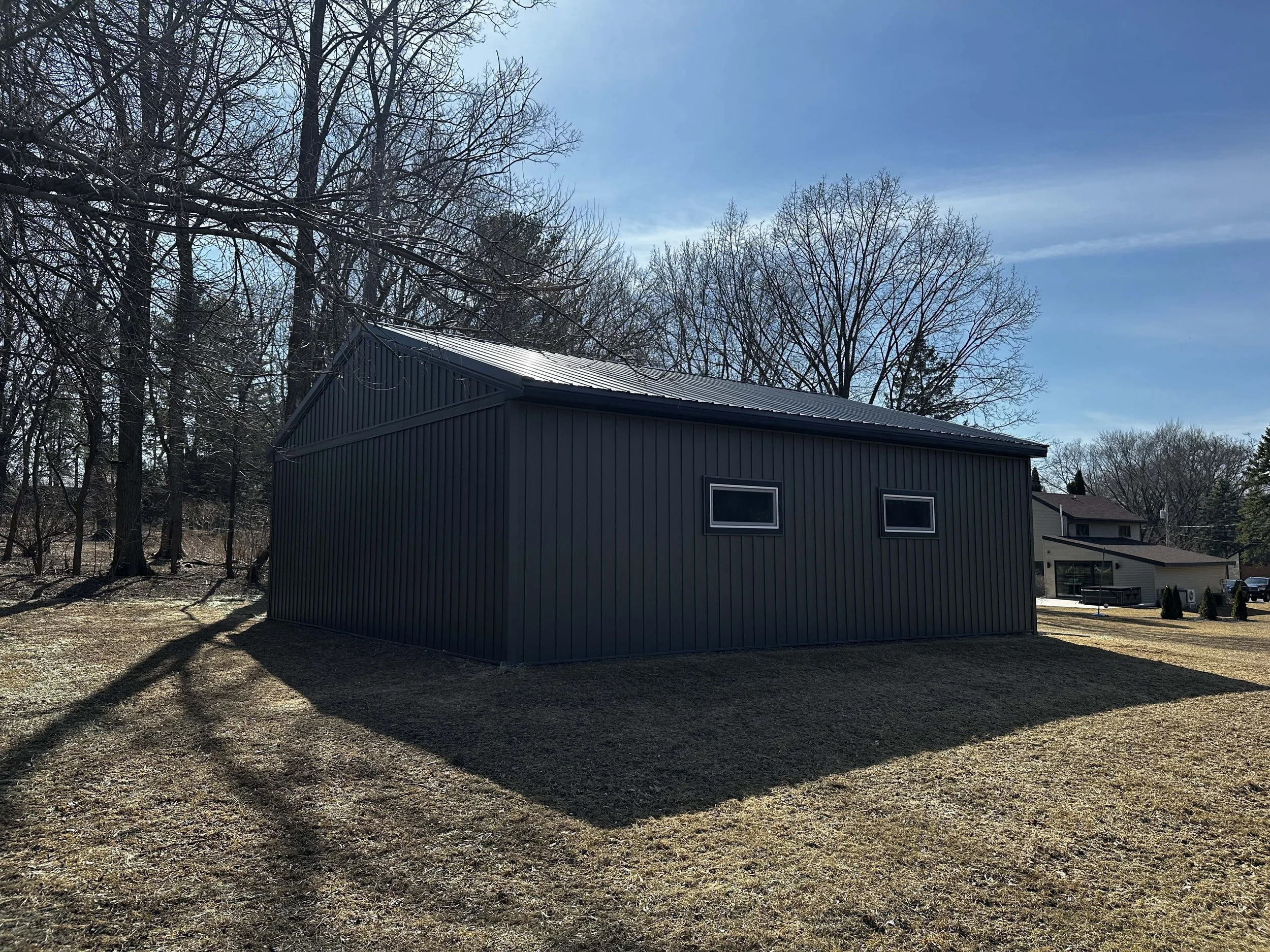 High-angle back view of the completed metal workshop structure and dark trim.