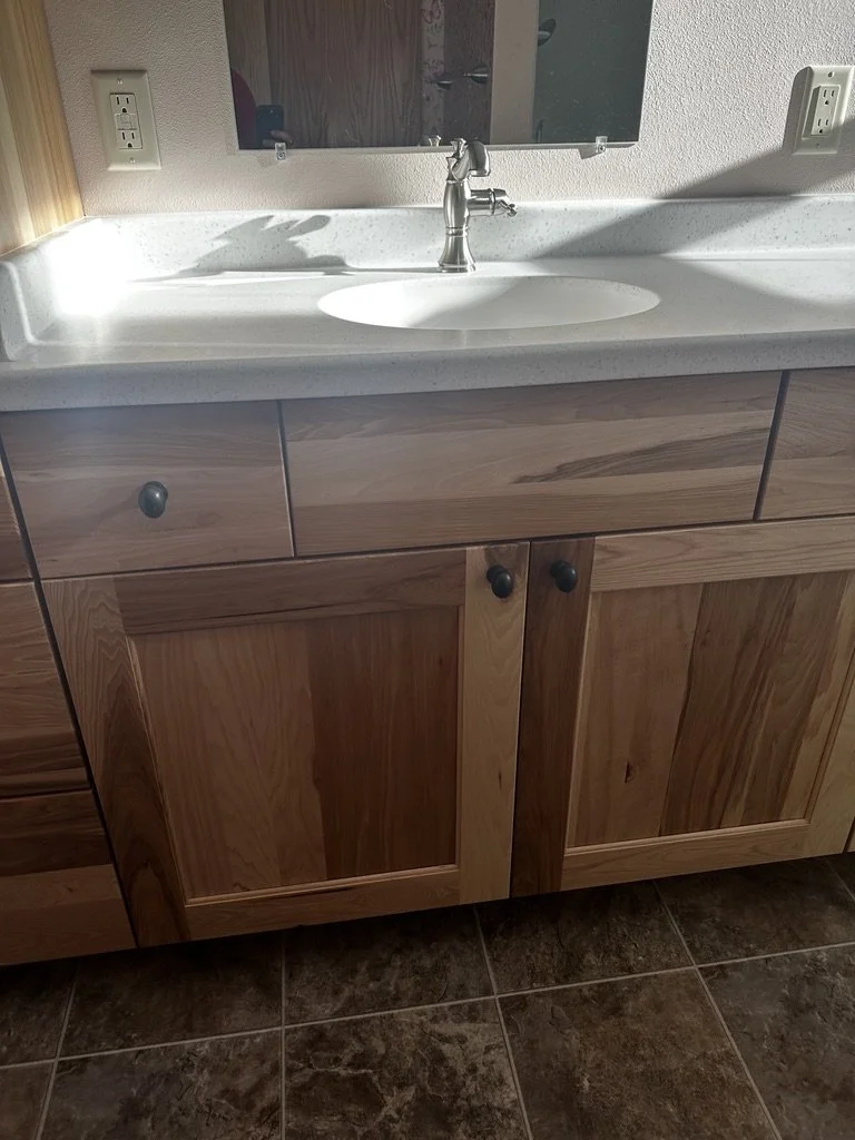 Close-up of a custom oak wood vanity cabinet base.