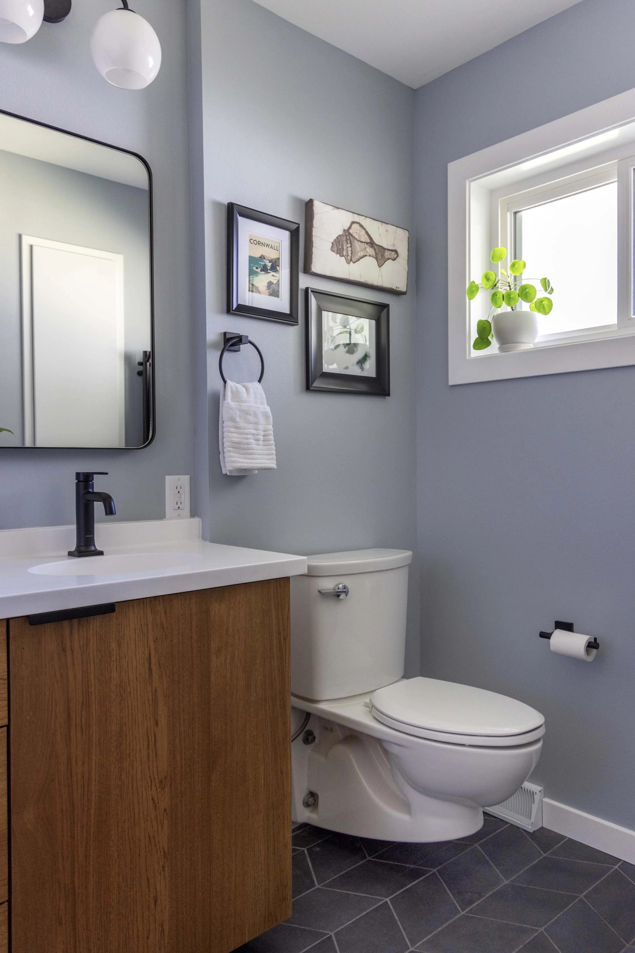 Primary bathroom remodel layout positioning a white toilet alcove next to a floating oak wood vanity cabinet setup.