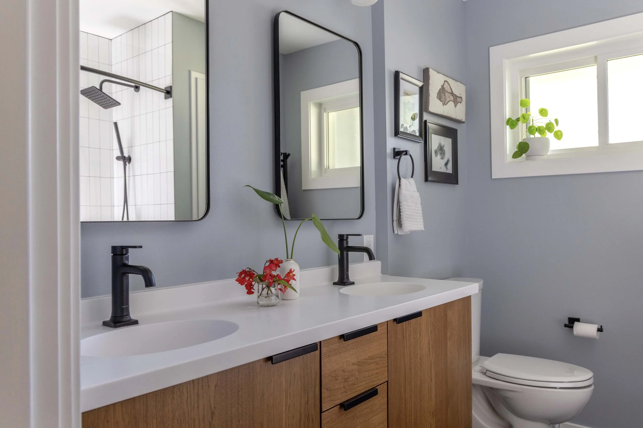 Side profile view of a white solid-surface vanity top with integrated sinks and black plumbing fixtures.