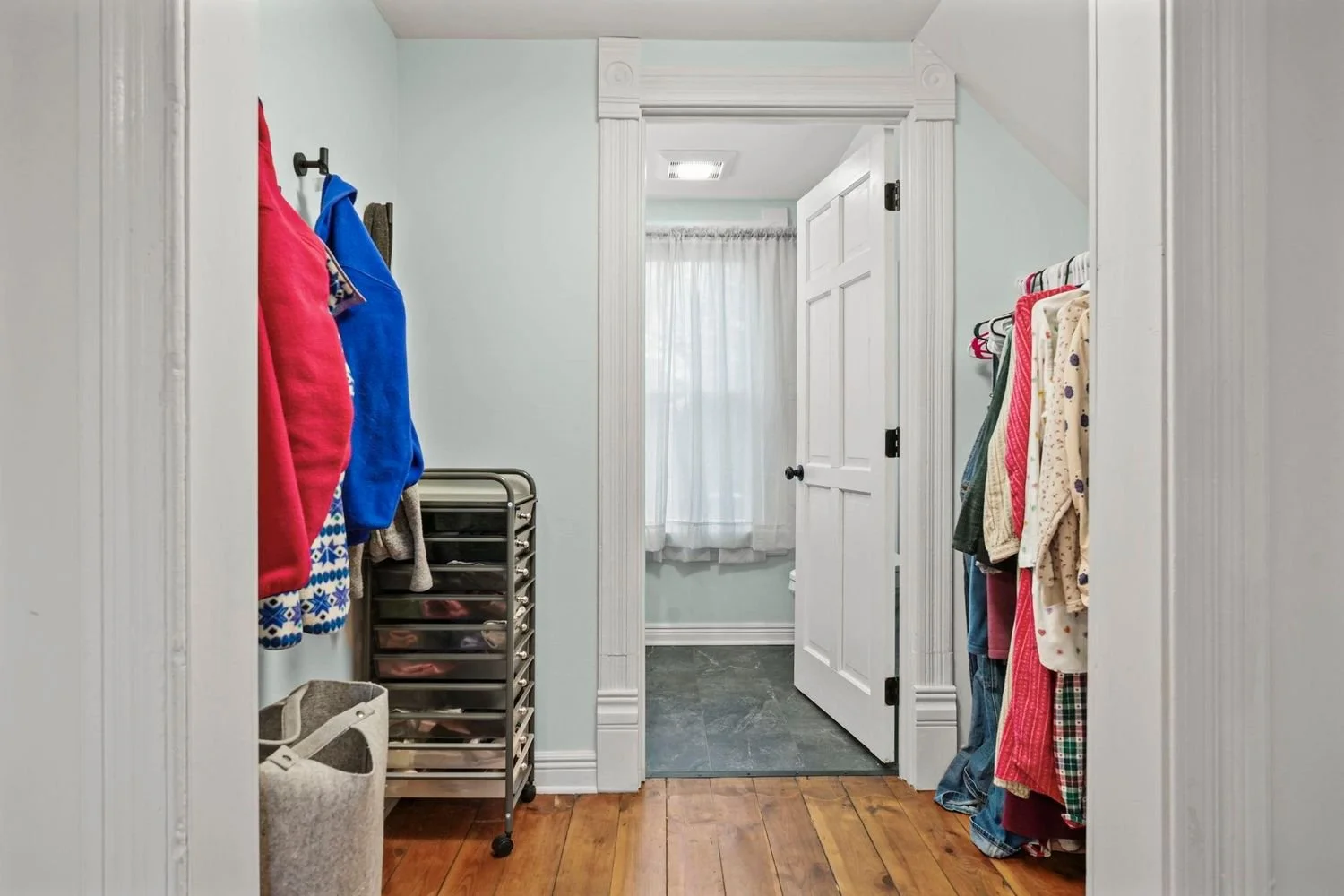 Functional mudroom and entryway update retaining original wood floors and classic wide door trim.