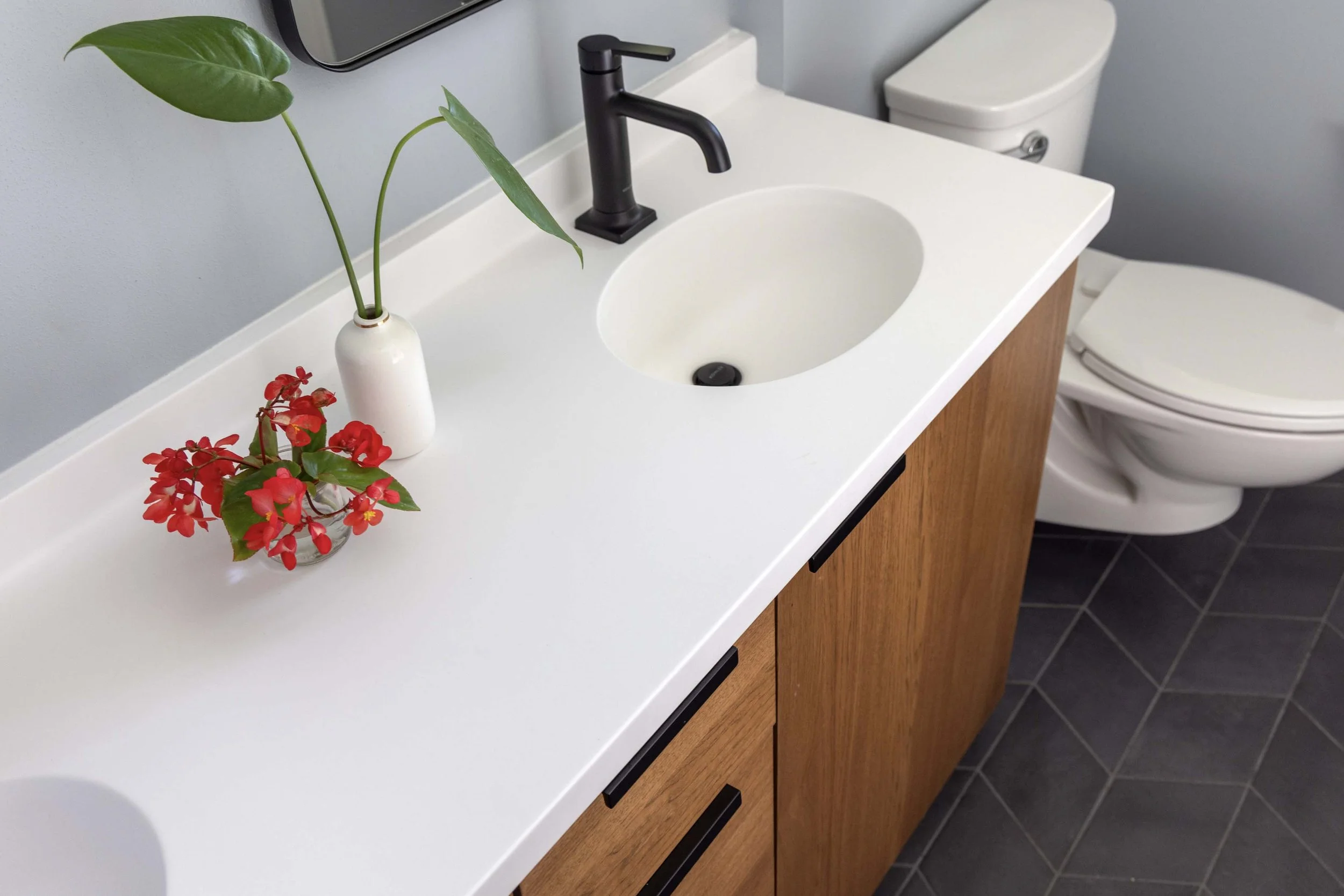 High-angle view of a custom primary bathroom vanity highlighting clean lines and integrated under-sink plumbing.