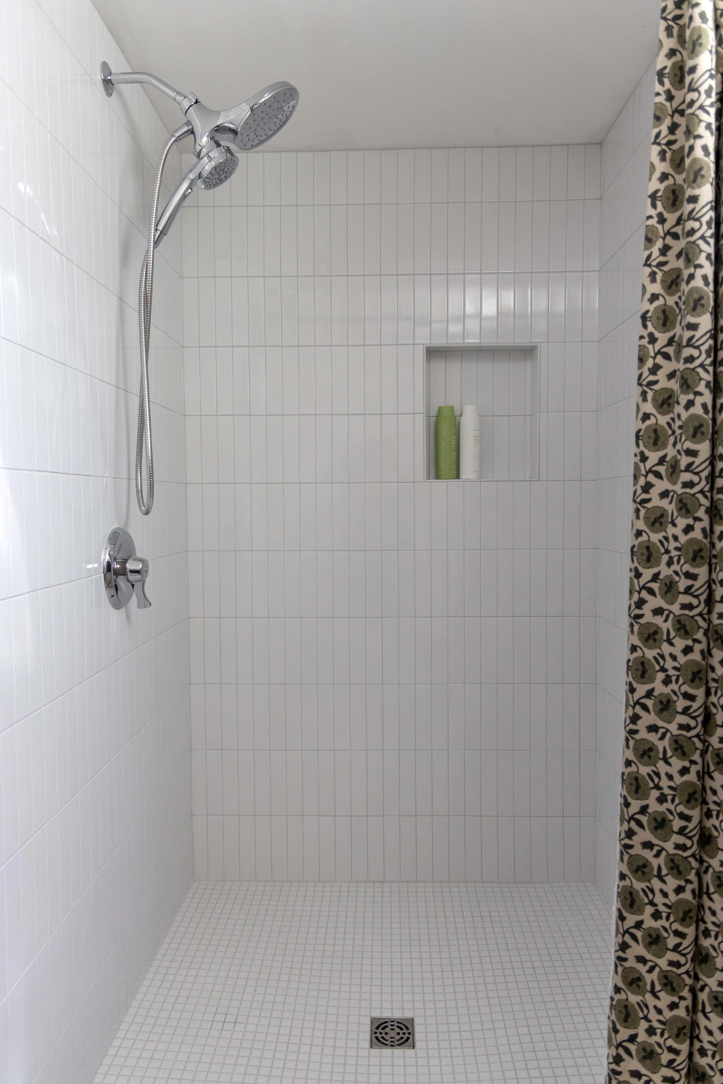 Basement bathroom renovation showcasing a vertical stack tile shower installation with a built-in niche.