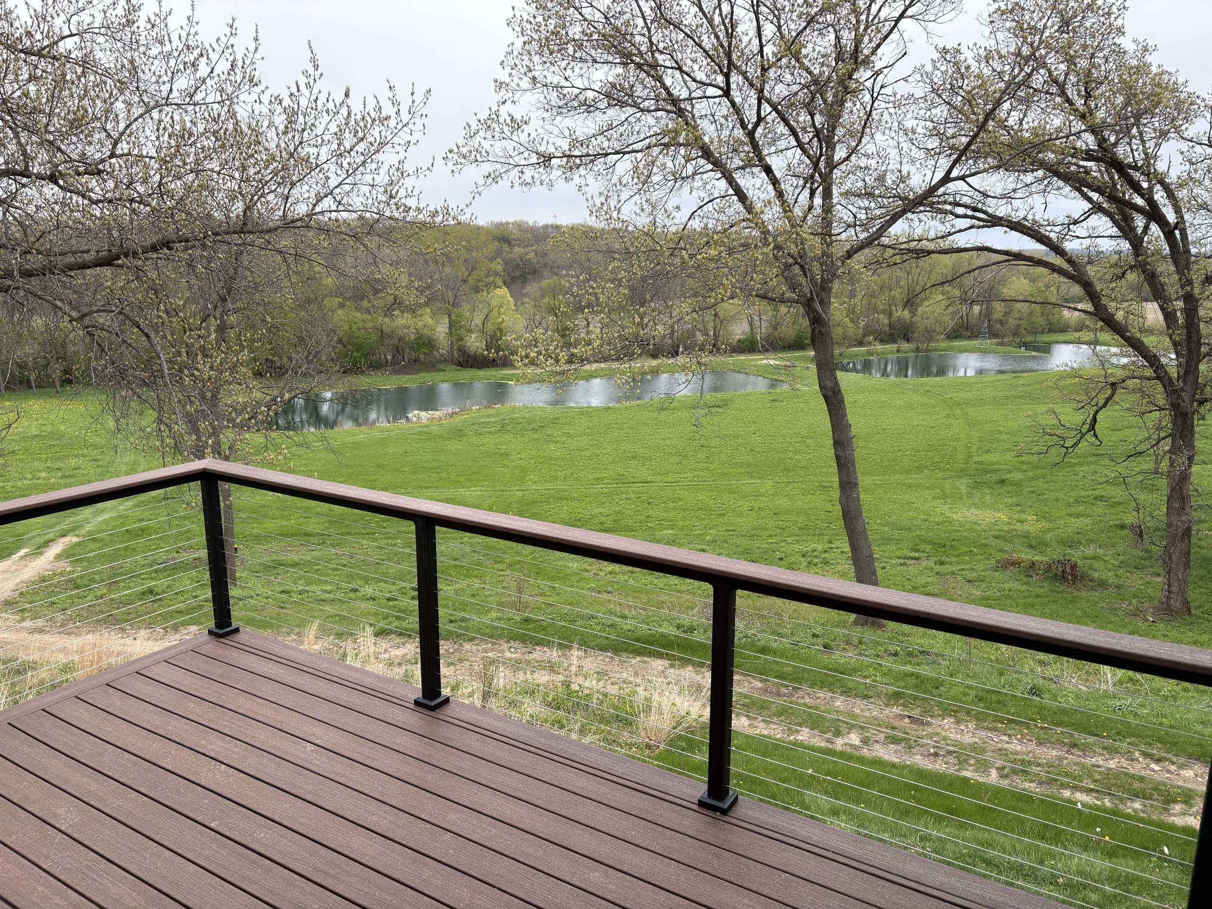 Finished outdoor living space by Root Down Remodeling showcasing a panoramic lakefront deck view.