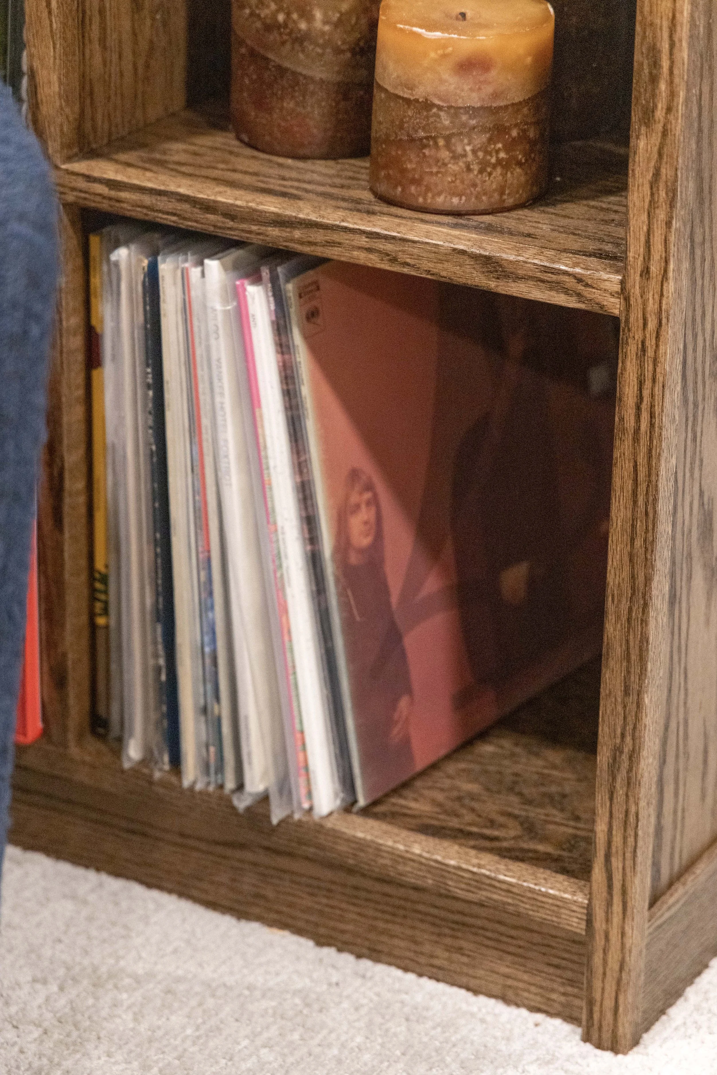 Custom wood cabinetry by Root Down Remodeling featuring integrated vinyl record storage slots.
