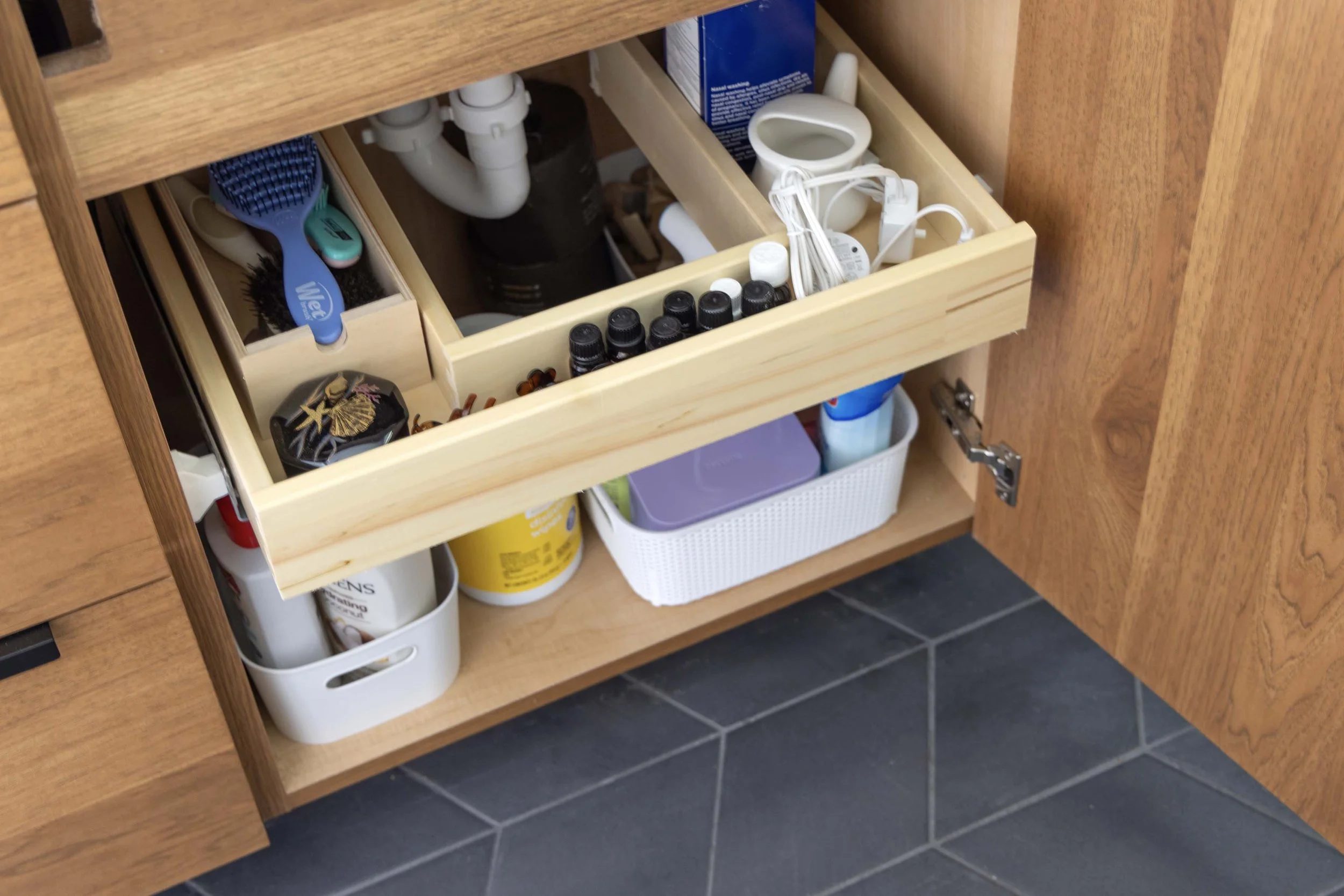 Custom U-shaped pull-out vanity drawer organizer built by Root Down Remodeling to maximize under-sink storage.