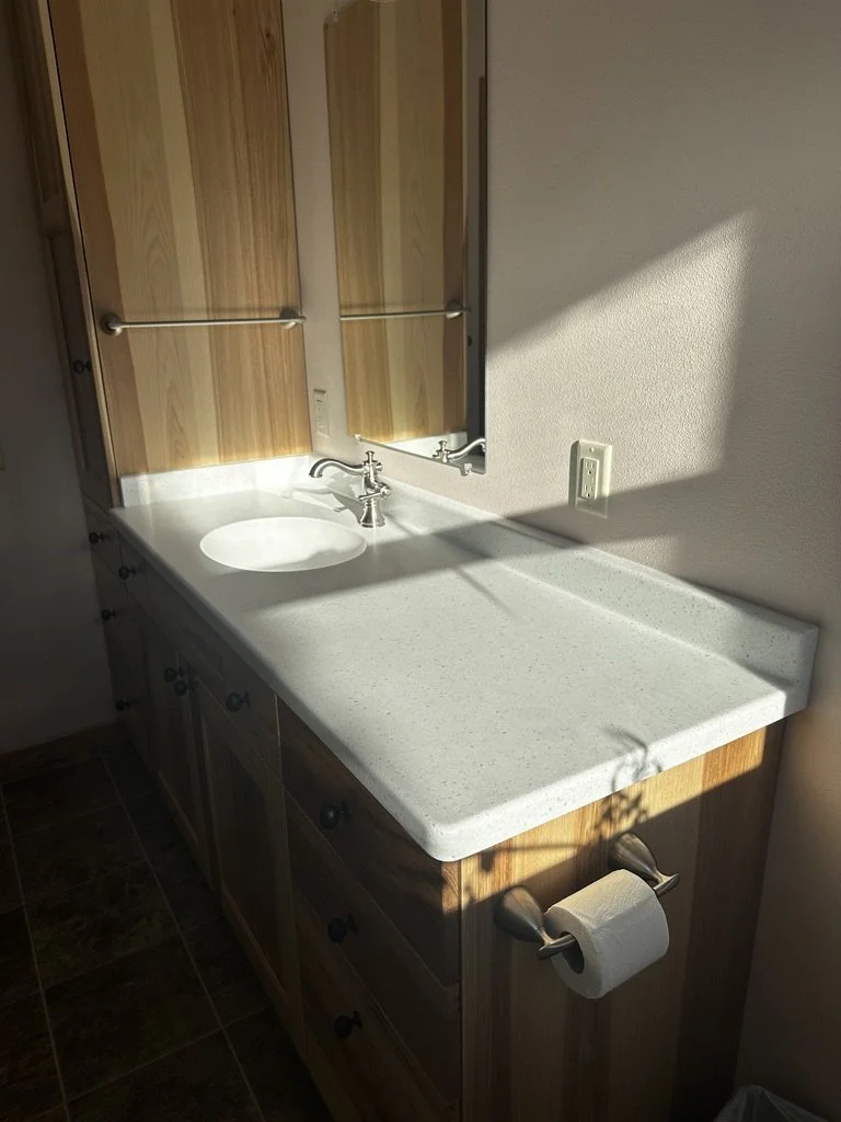 Custom-fabricated Corian Aurora vanity countertop with an integrated sink.