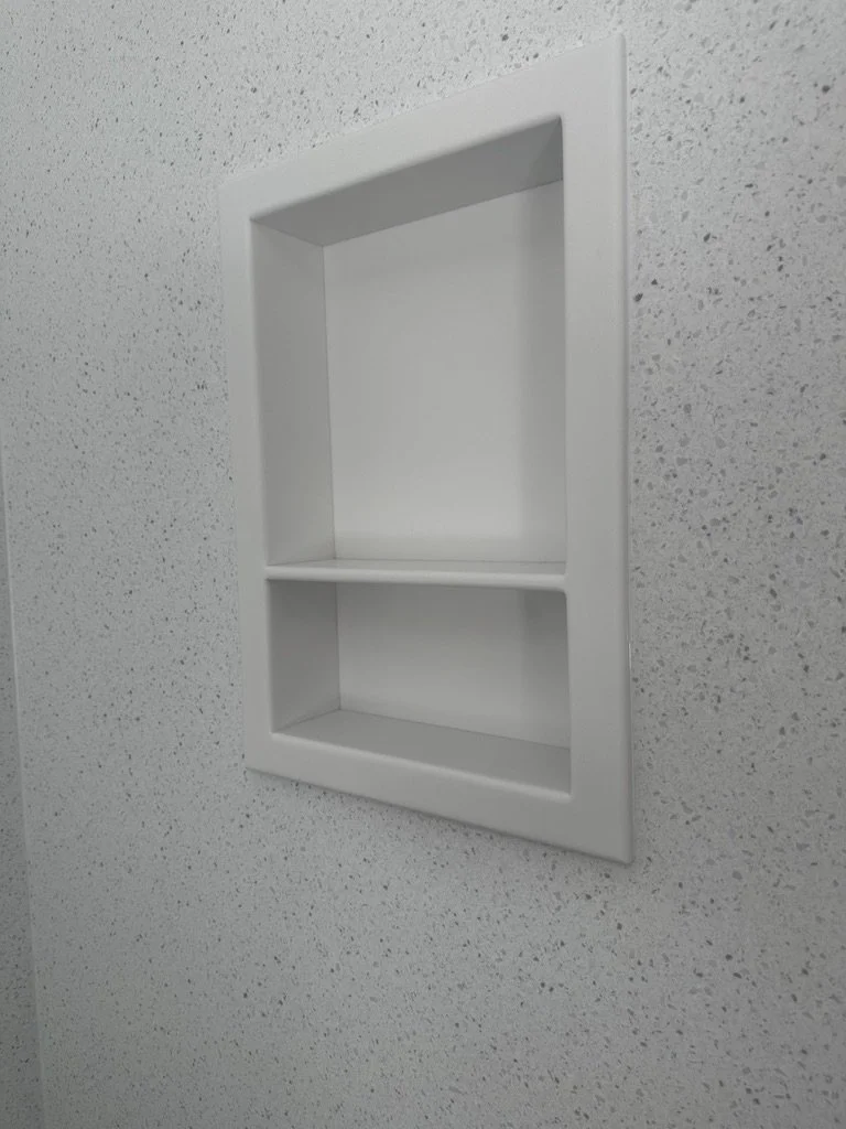 Dual-shelf recessed shower niche providing sleek storage inside a walk-in shower.