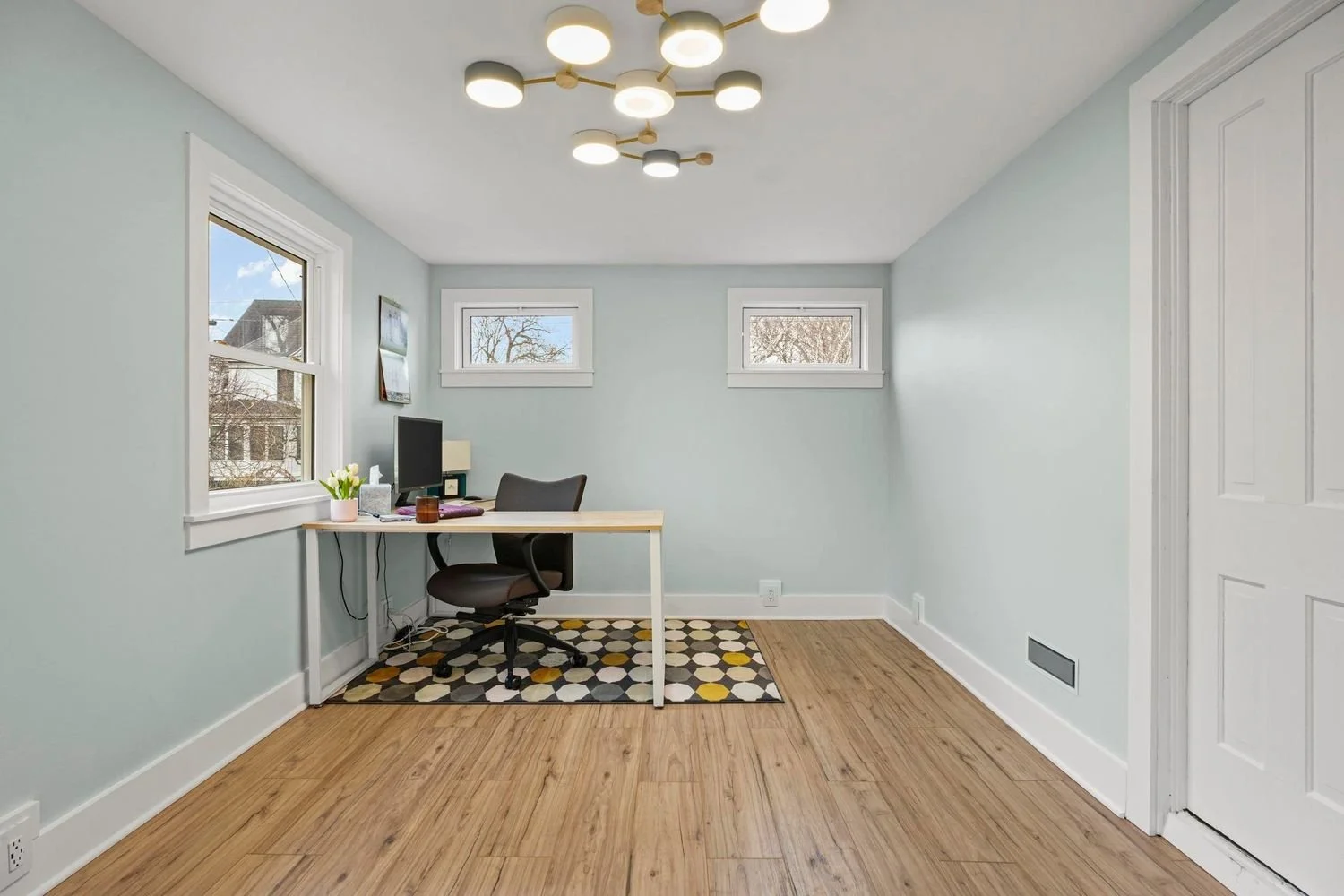 Bright home office remodel featuring a contemporary multi-bulb ceiling light fixture and hardwood floors.