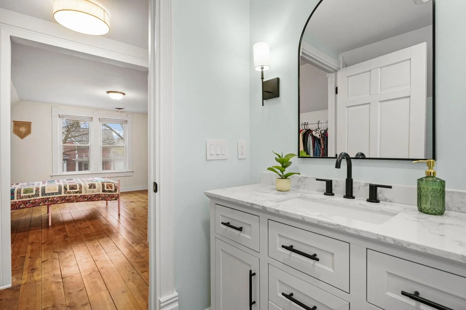  Modernized bathroom vanity installation with a white stone countertop blending into historic home architecture.