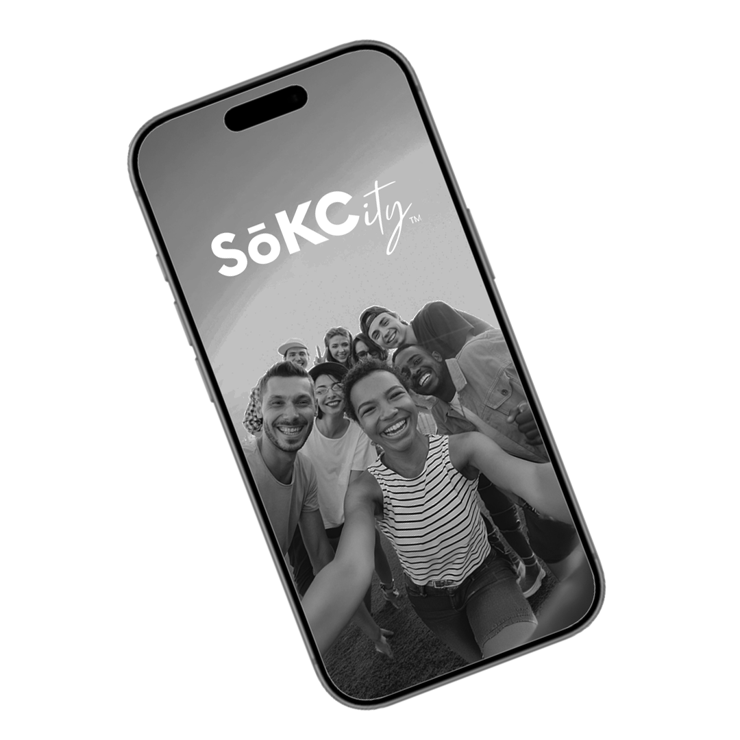 A smartphone displaying a group selfie of smiling diverse young people outdoors, with the logo 'SoKCty' on the screen.
