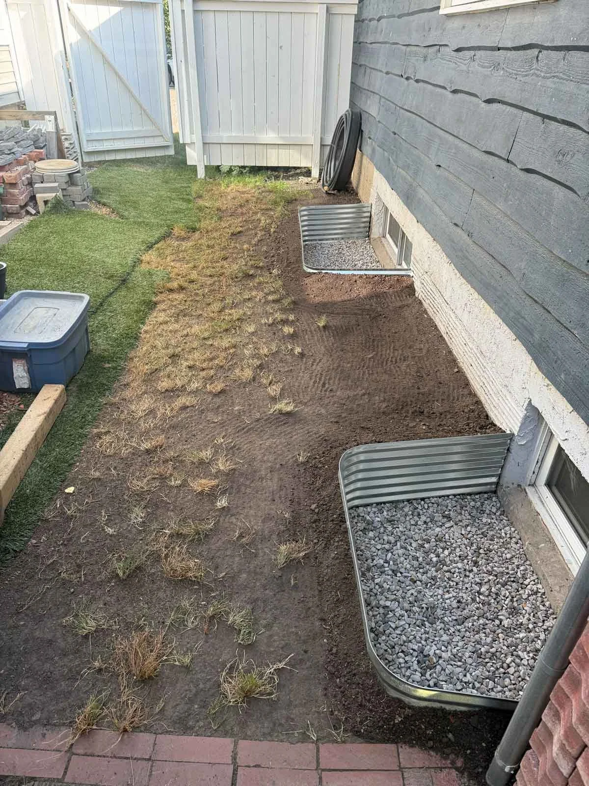 Window well with protective cover installed to keep out debris and reduce maintenance.