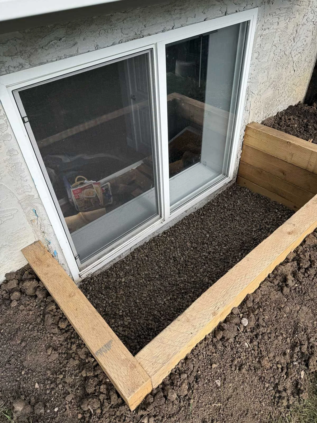 Galvanized steel window well installed on an existing home foundation.