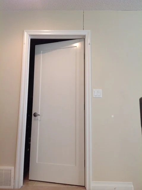 white door with house crack on wall.