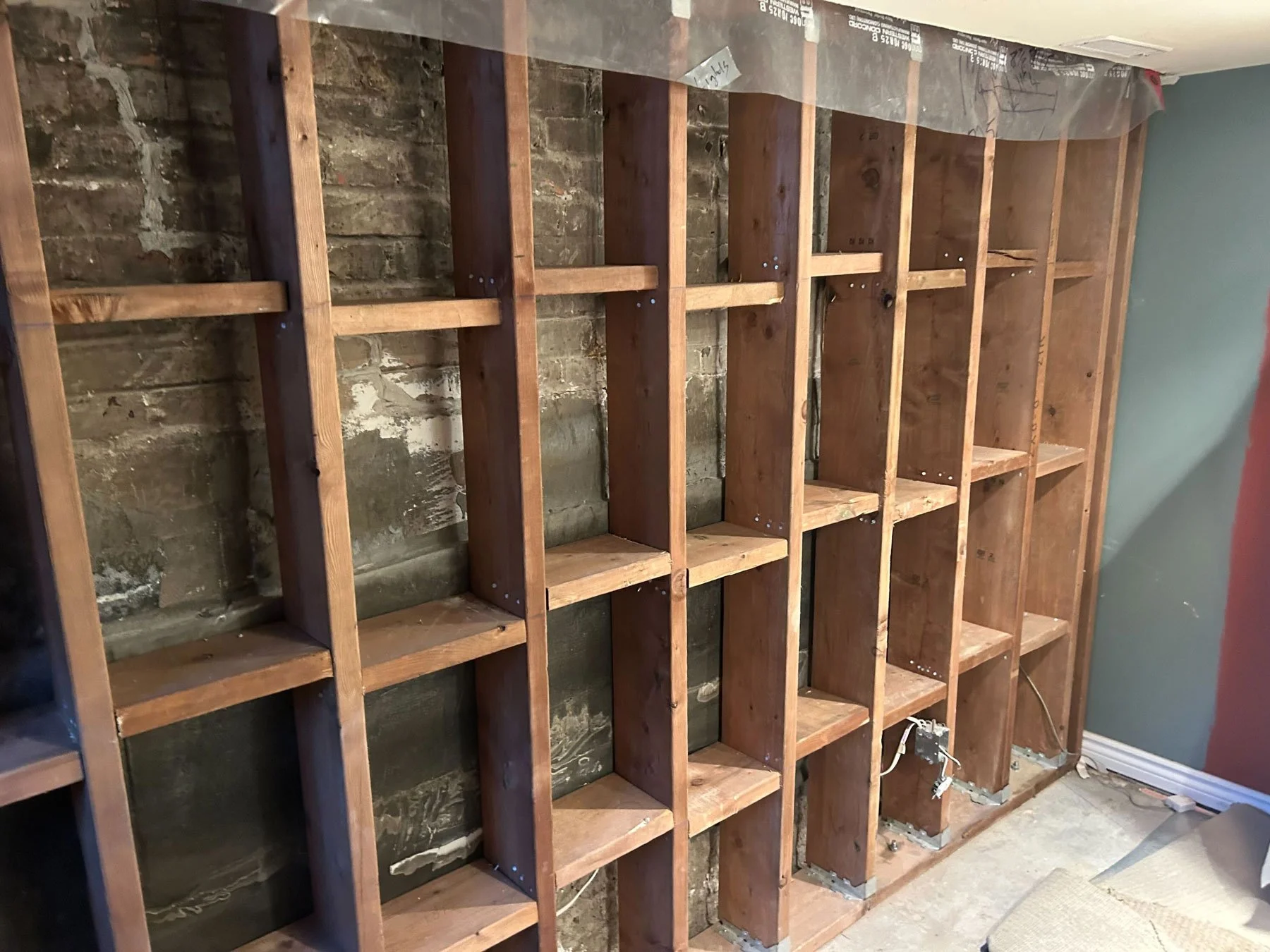 Interior PWF wall system providing structural support for a damaged foundation wall.