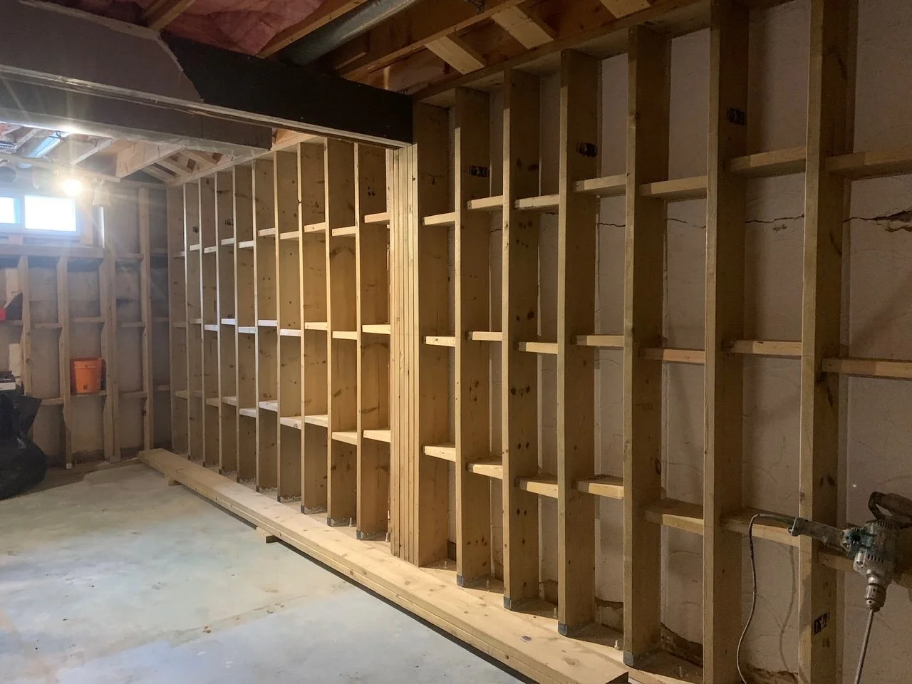Reinforced pressure-treated wood foundation wall installed along basement perimeter to stabilize a cracked foundation.