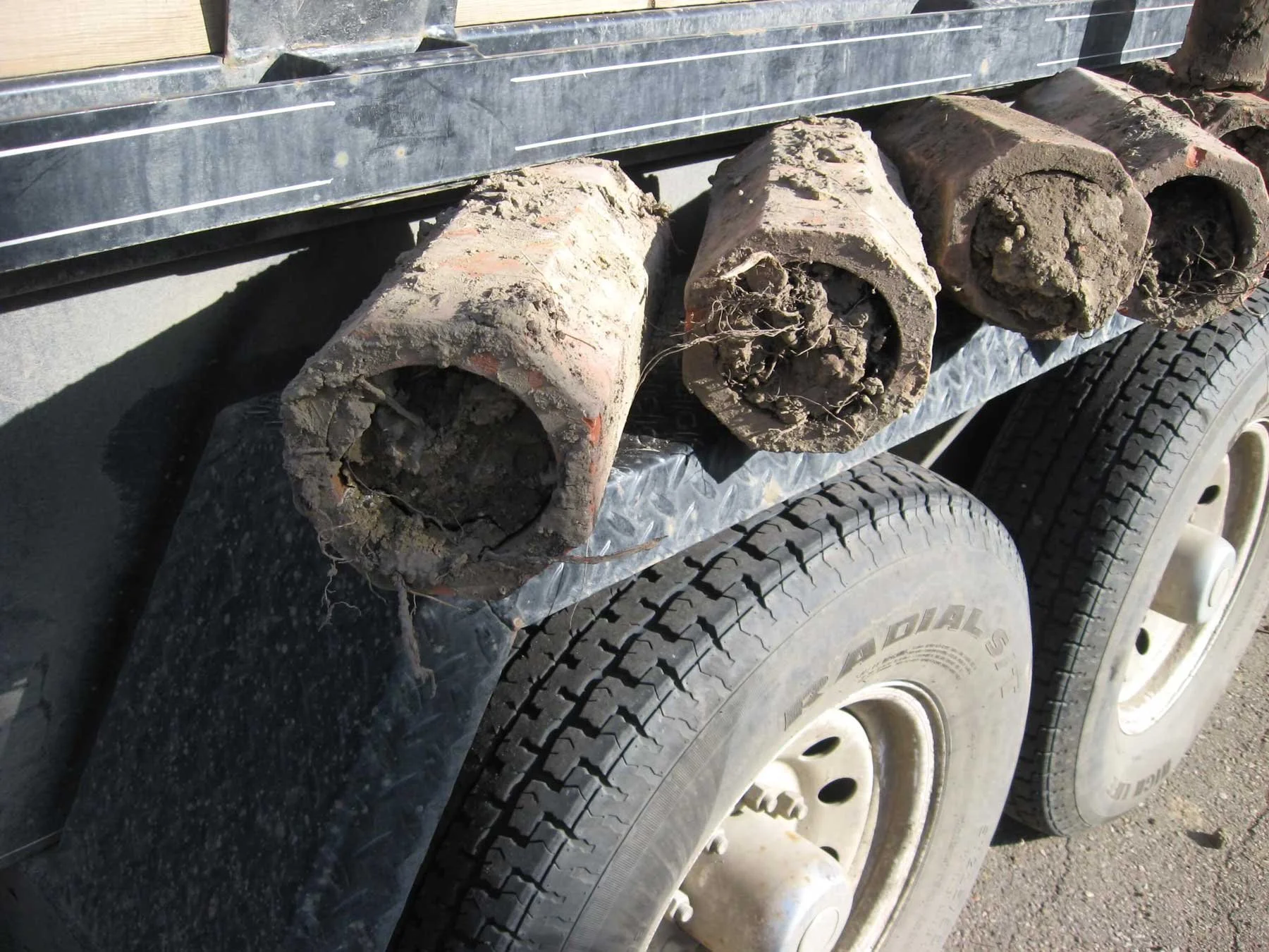 Old clay weeping tiles removed during excavation, showing deterioration and blockage that commonly occurs in original drainage systems.