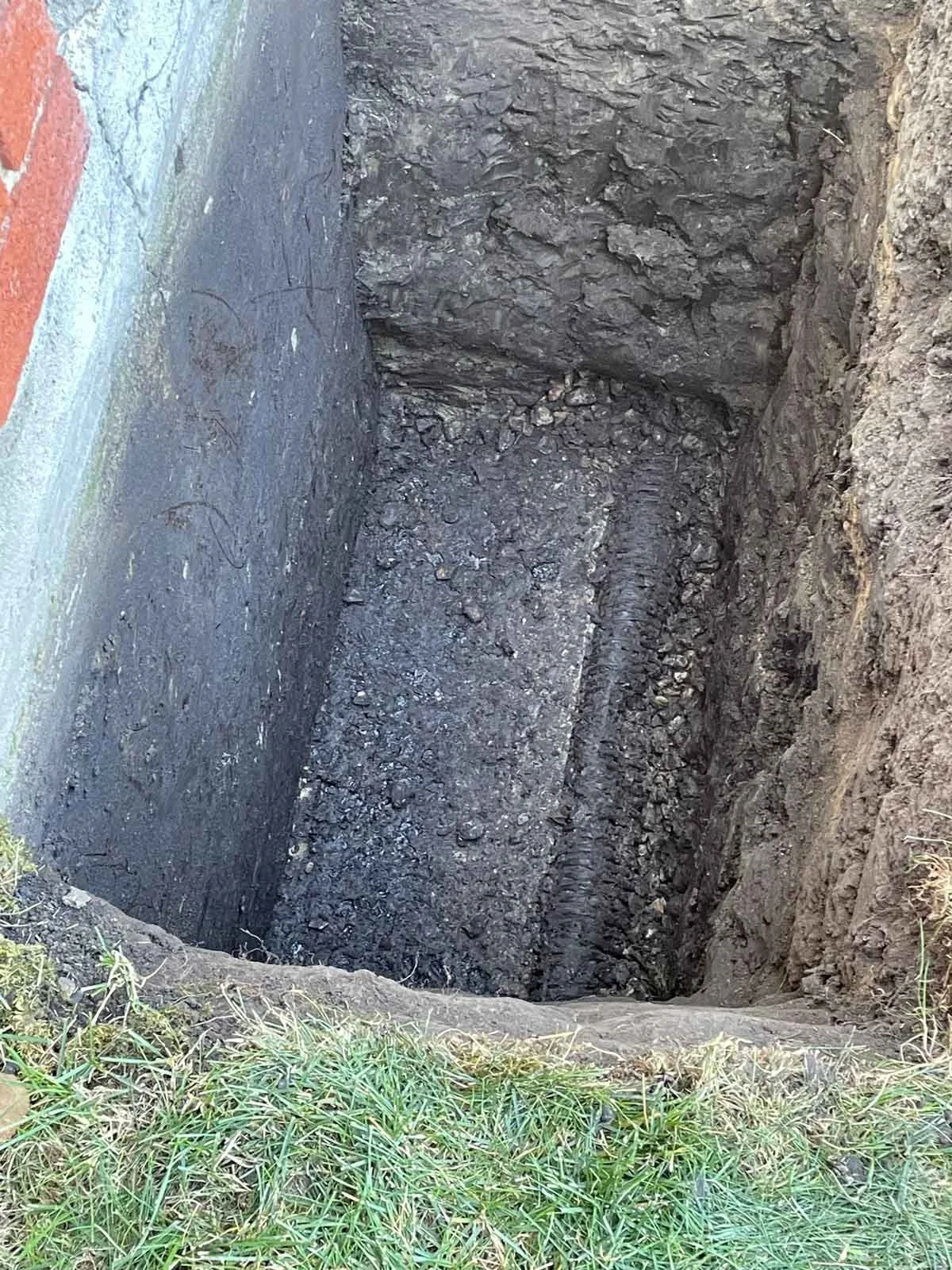 Exposing foundation crack and testing weeping tile during repair.