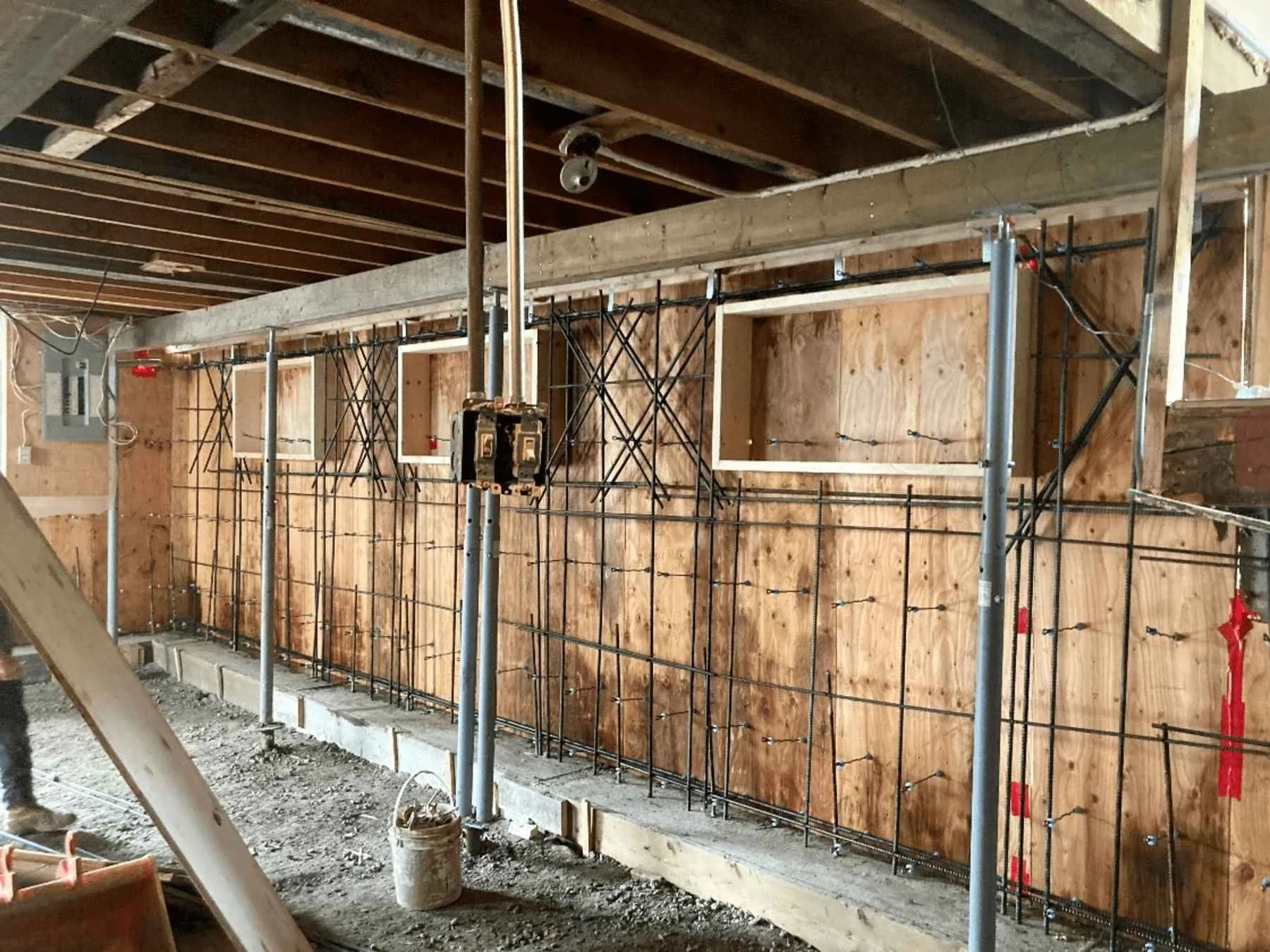 
Interior view of foundation replacement showing concrete formwork, rebar reinforcement, and temporary steel supports.