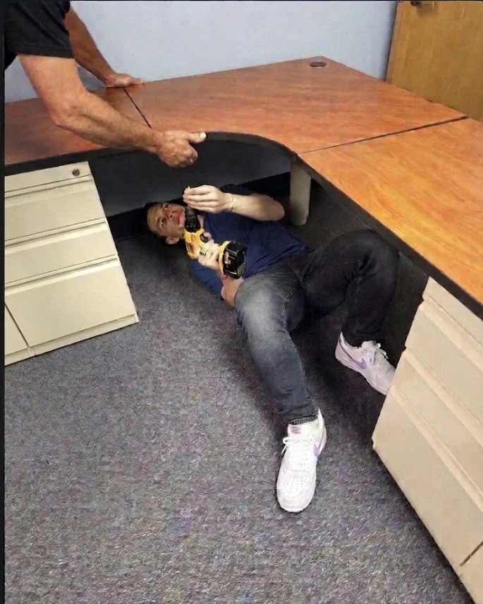 A professional assembling an office desk