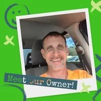 Smilng man sitting in a car with a green border and text that reads 'Meet your Owner!'