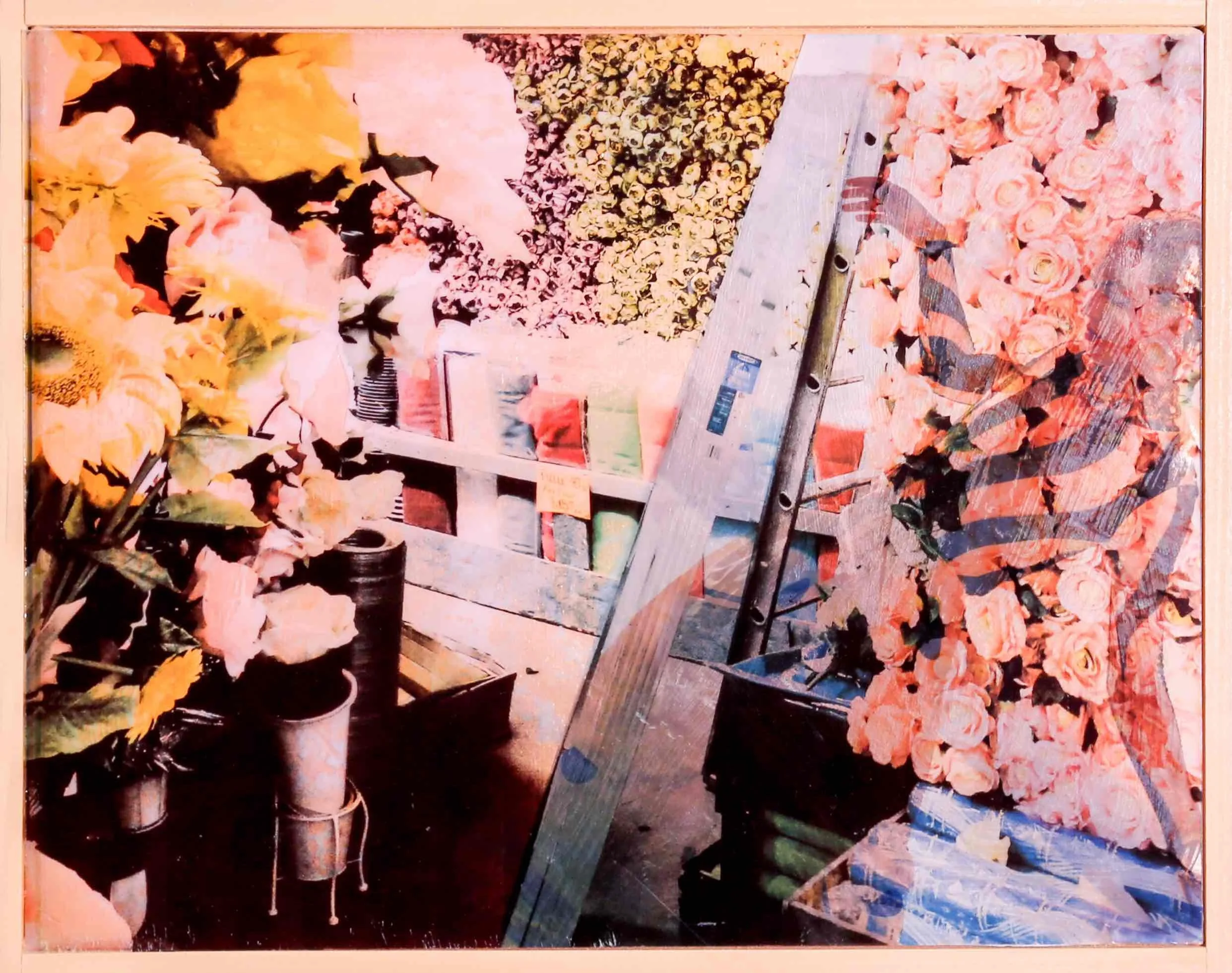 Display of artificial flowers, including pink roses and other floral arrangements, on shelves at a store.