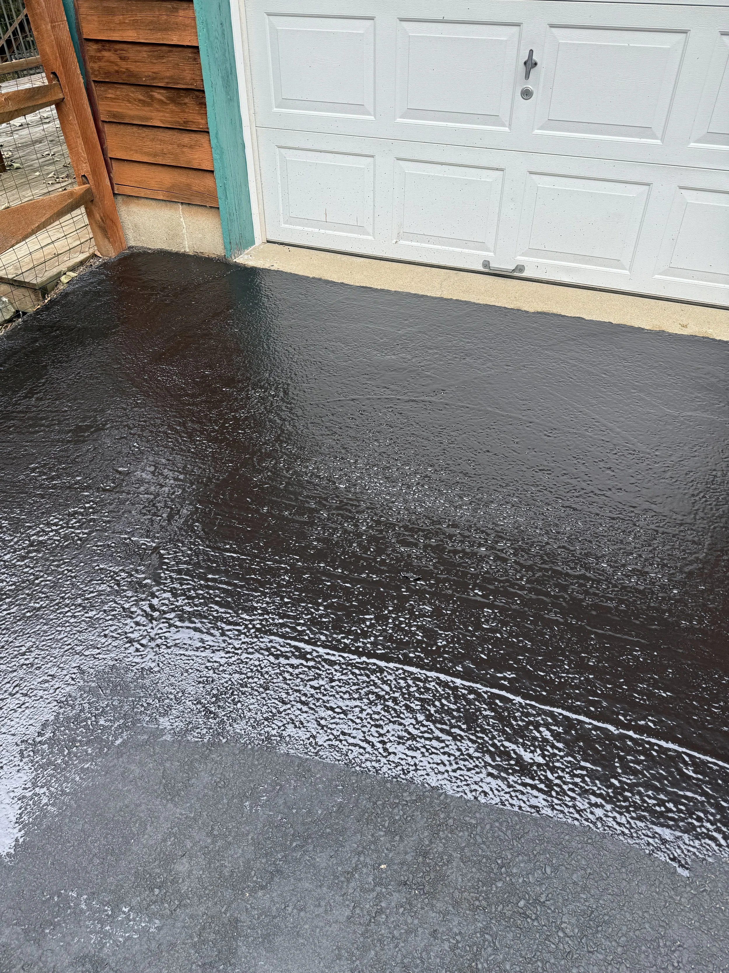 Driveway showing original and sealcoated asphalt.
