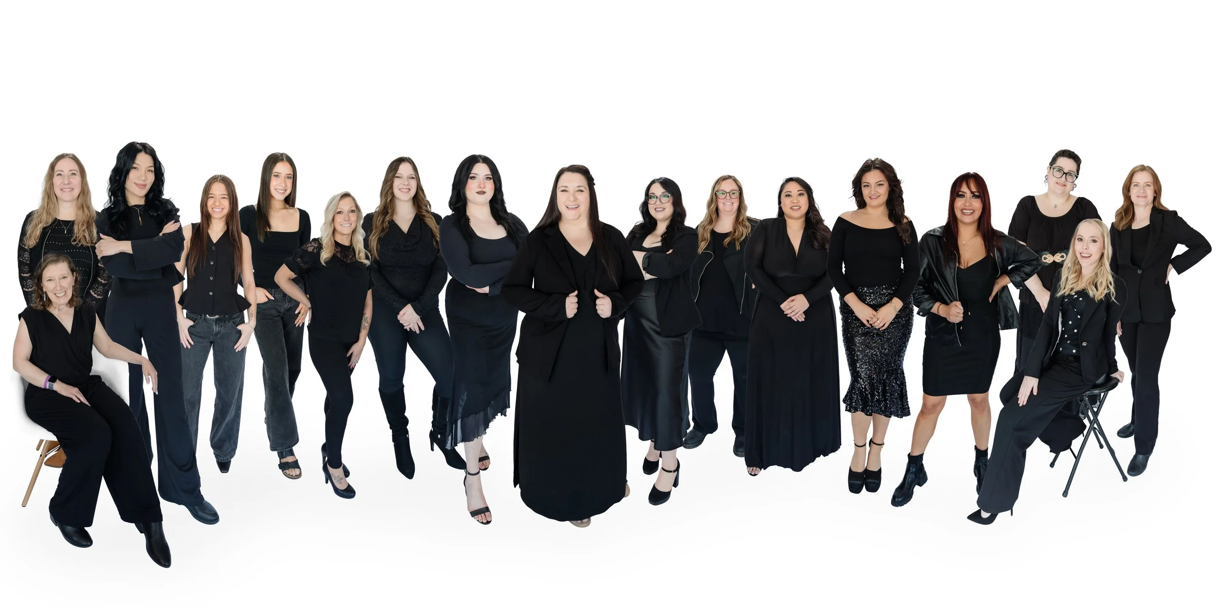 Group of women posing together against white background, wearing black outfits, in a professional or fashion photoshoot setting.