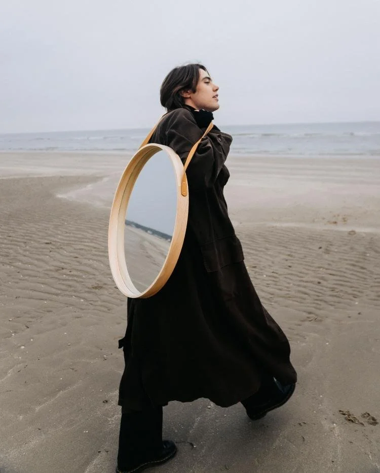 person walking on the beach with mirror