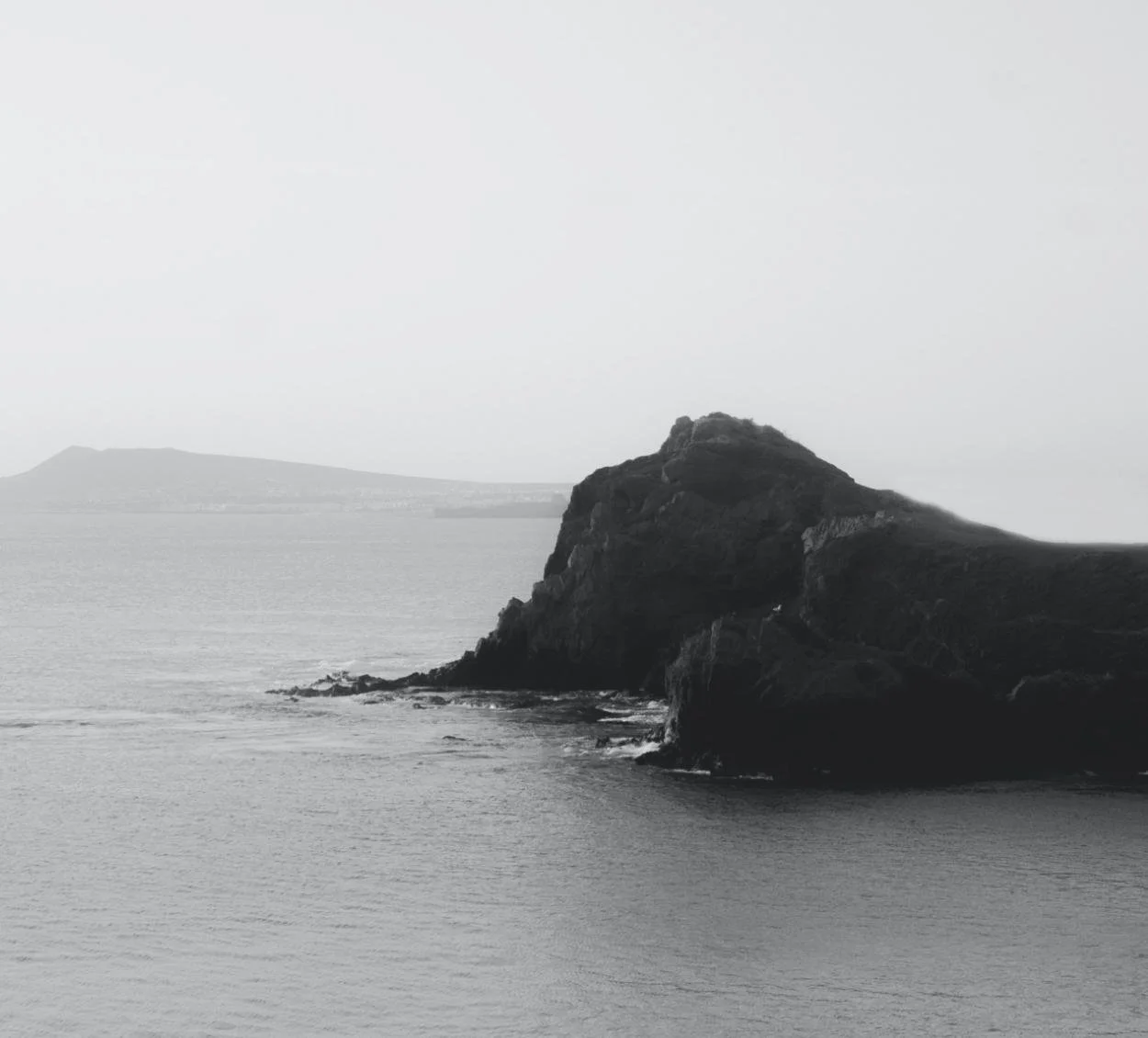 black and white photography ocean and rock
